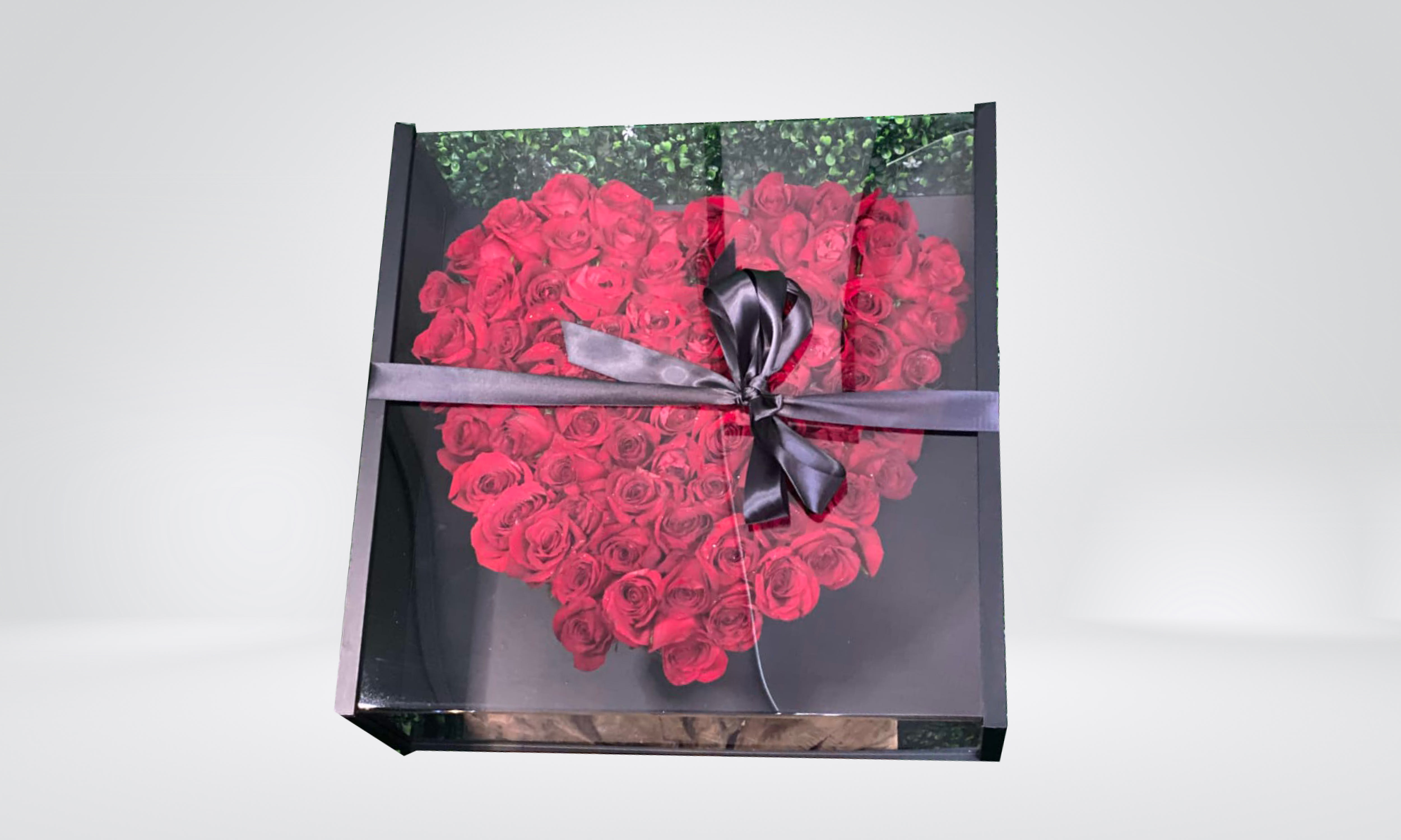Heart-shaped box of red roses tied with a black ribbon