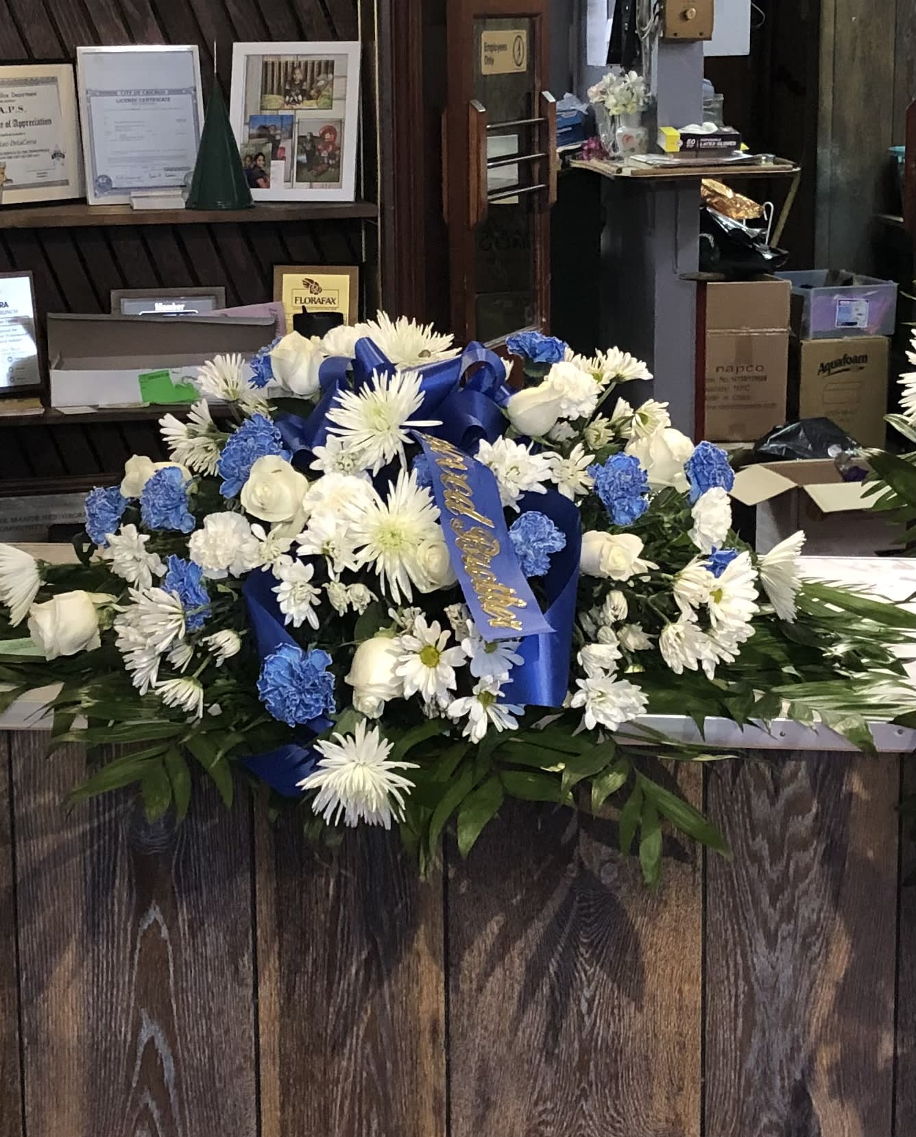 Large blue and white floral spray with ribbon on a counter