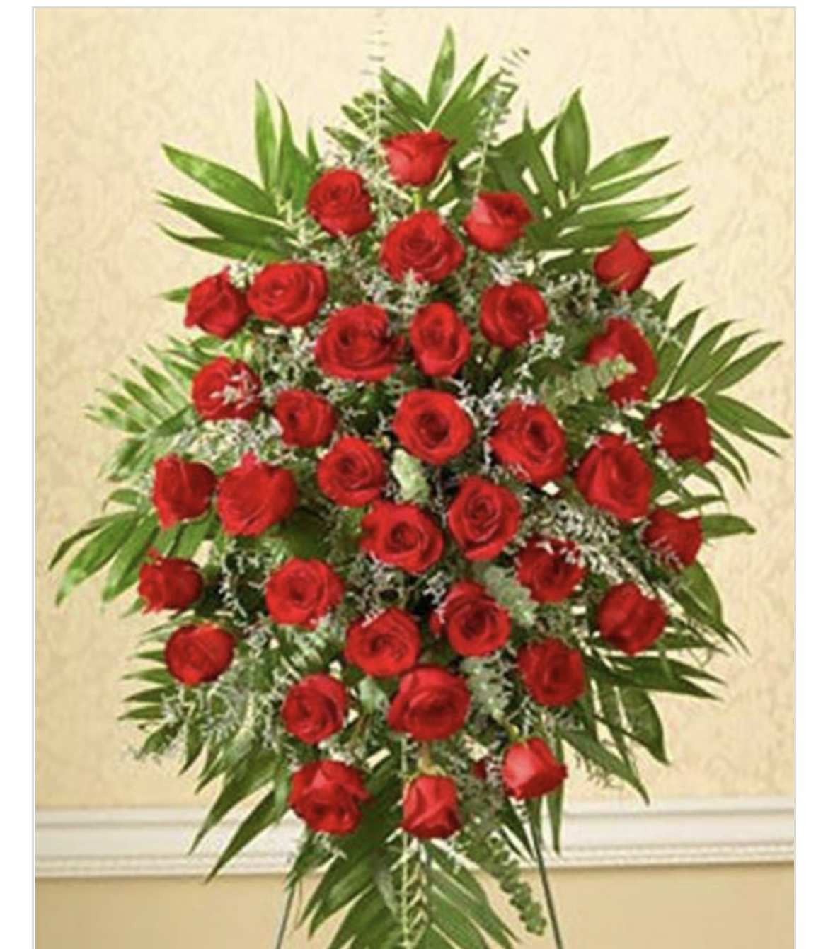Standing spray of red roses with greenery