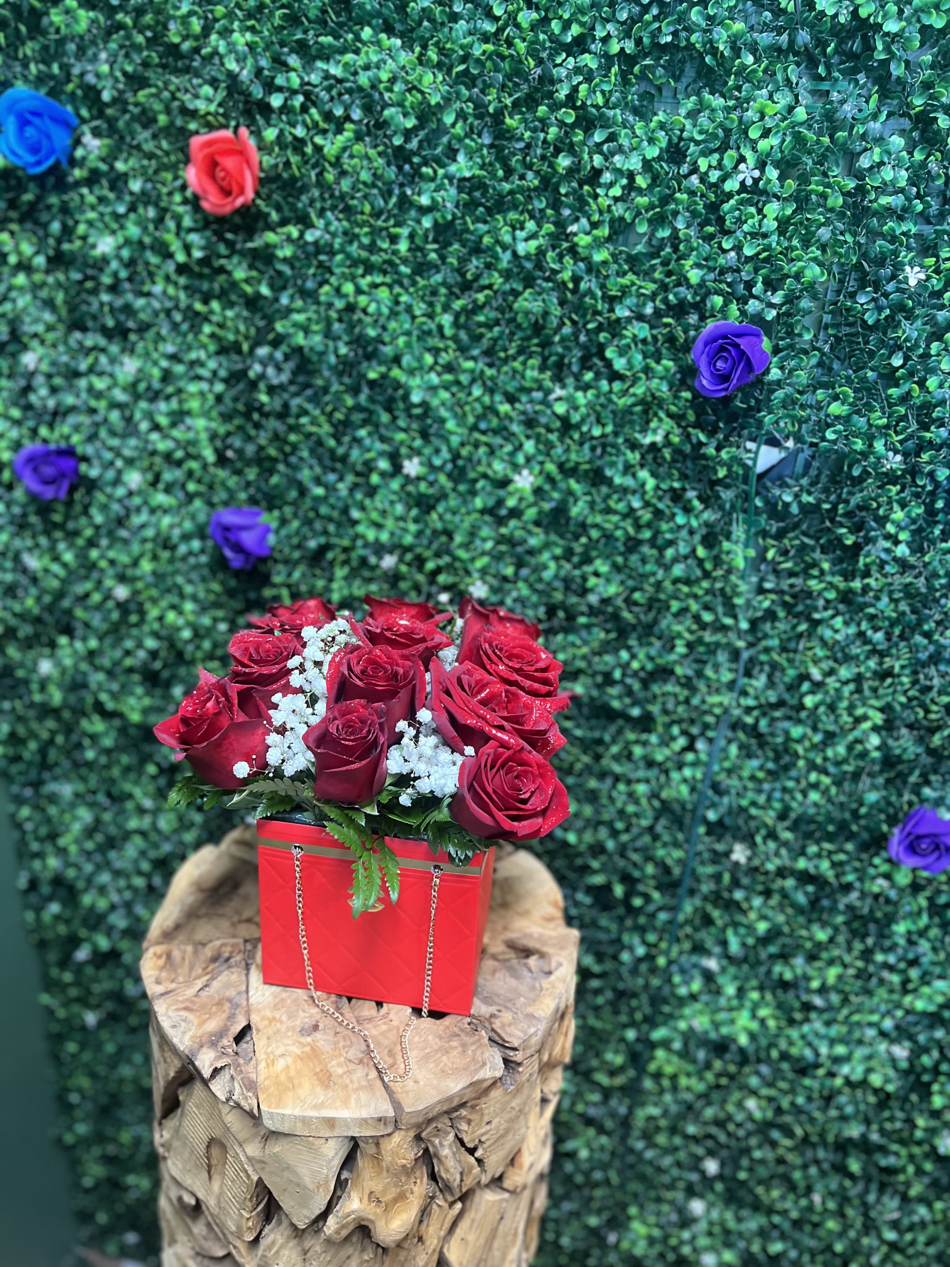 Red roses in a red box with white filler flowers