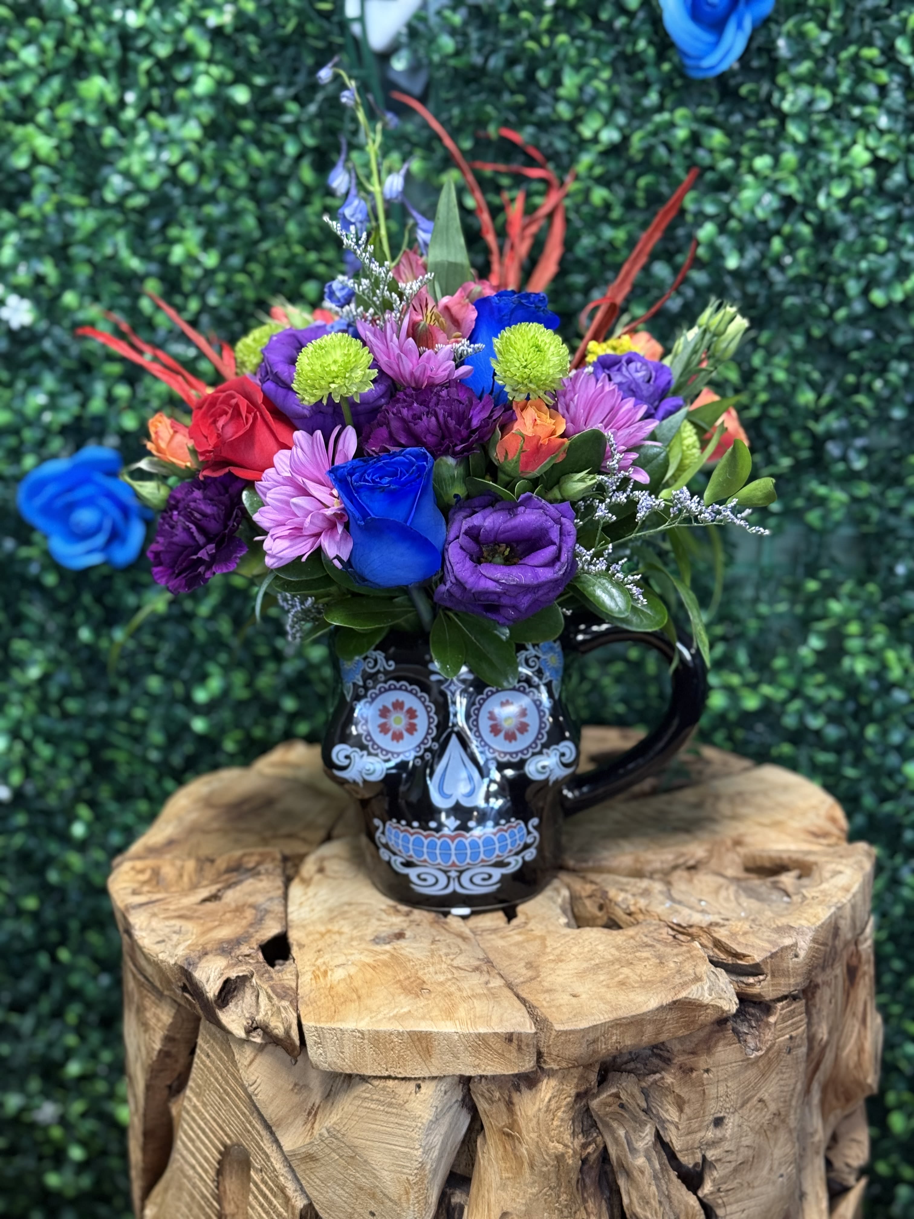 Colorful bouquet in a black skull mug on a wooden stand