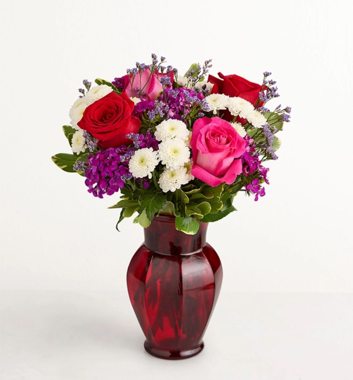 Bouquet of red and pink roses in a red glass vase