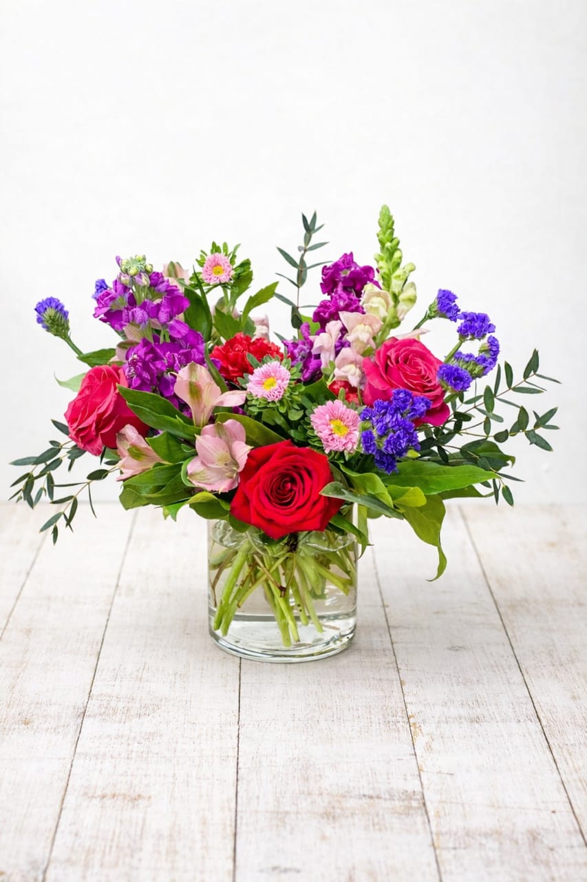 Color Me Loved  - Product Description  Color Me Loved is a romantic Valentine’s Day flower arrangement in a clear glass vase, hand designed by a local East Moline florist with delivery available.  Color Me Loved features a lively blend of red, pink, and purple blooms accented with fresh greenery, creating a balanced, joyful, and heartfelt design, with flowers selected at the designer’s discretion based on seasonal availability.  Color Me Loved is available for Valentine’s Day flower delivery in East Moline, Moline, Rock Island, Silvis, Davenport, and Bettendorf, making it a beautiful way to share love throughout the Quad Cities. 