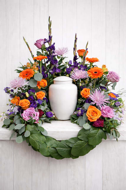 Colorful floral wreath with a white urn in the center