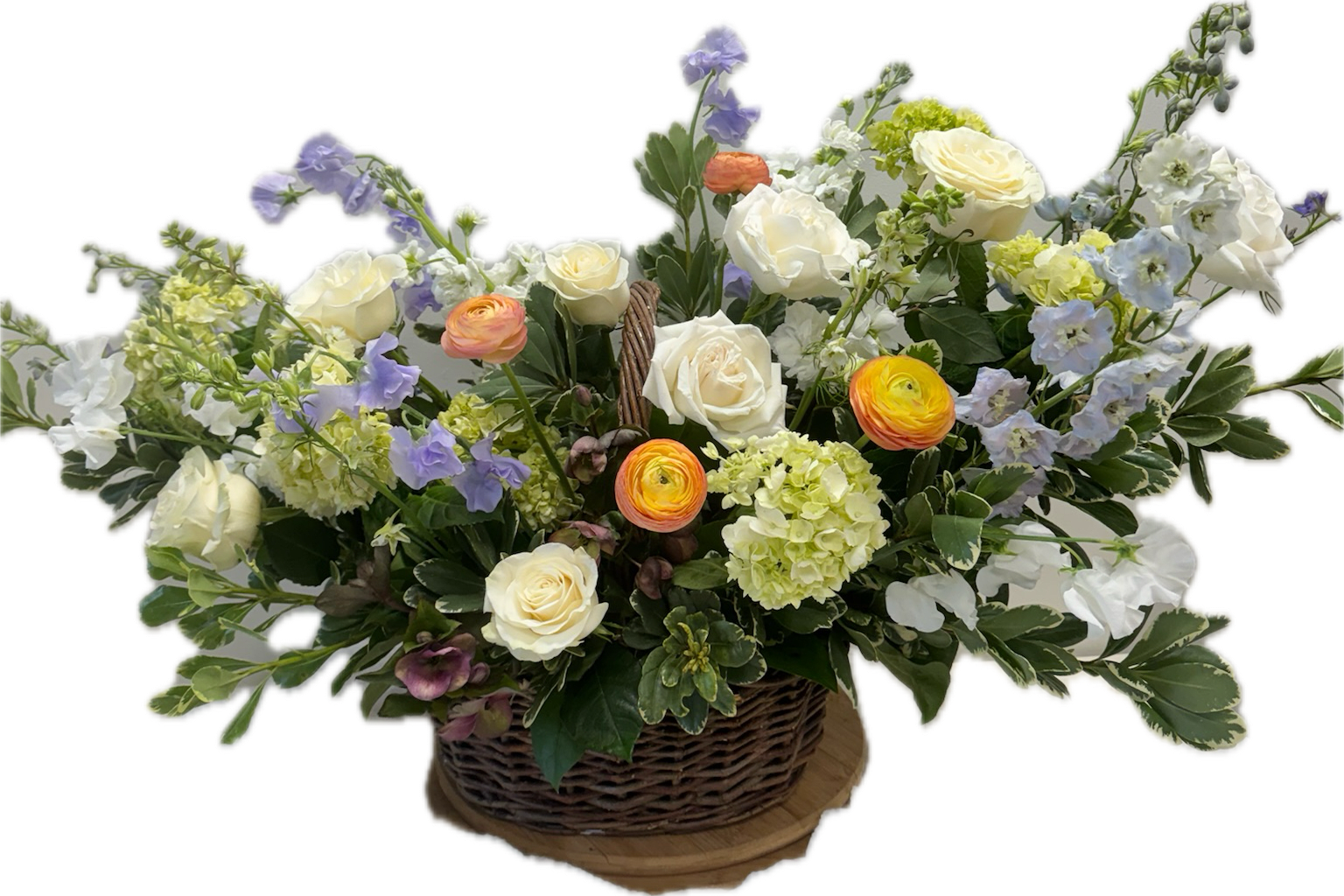 Basket arrangement of white roses, ranunculus, and pastel blue flowers