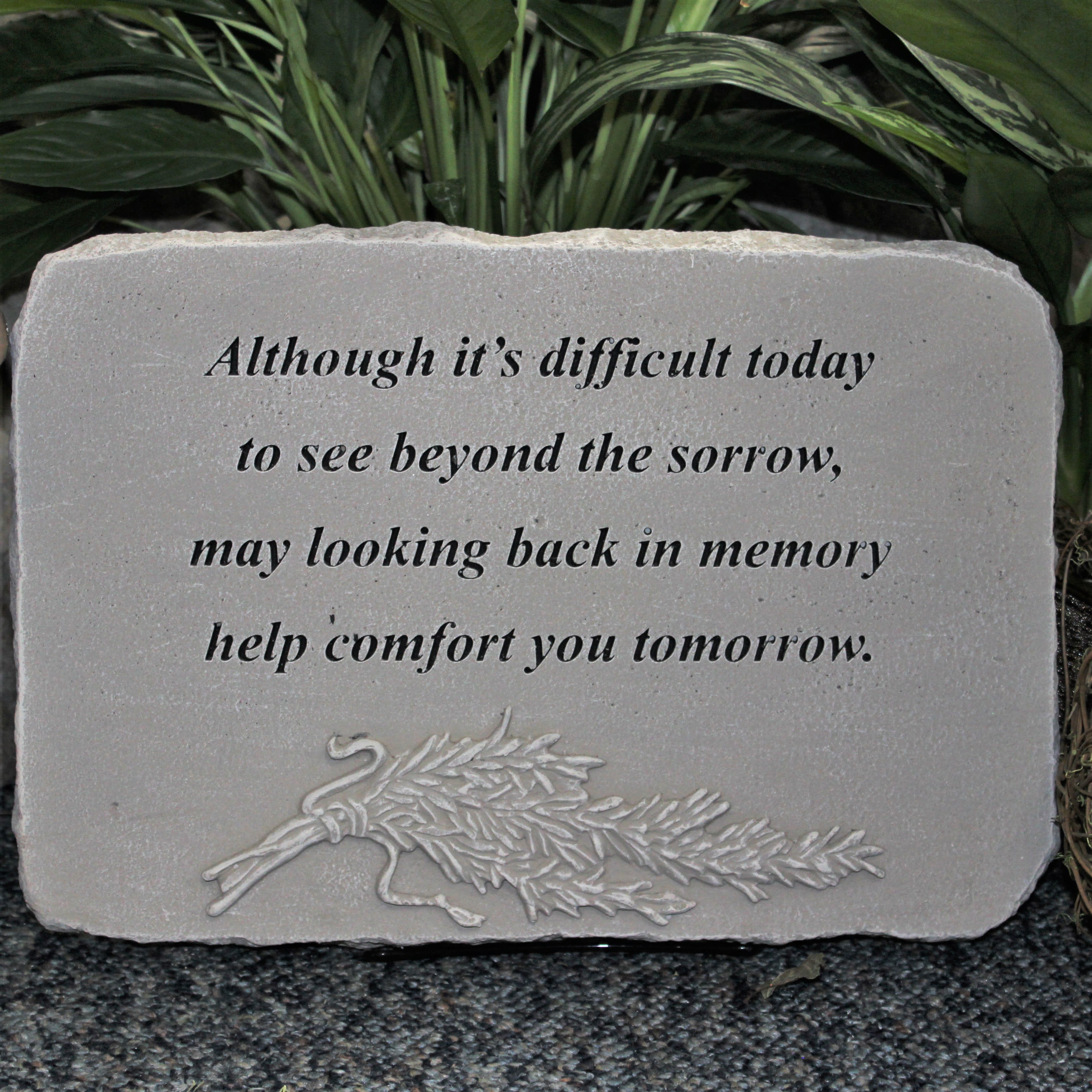 Stone memorial plaque with a sympathy quote and carved floral design