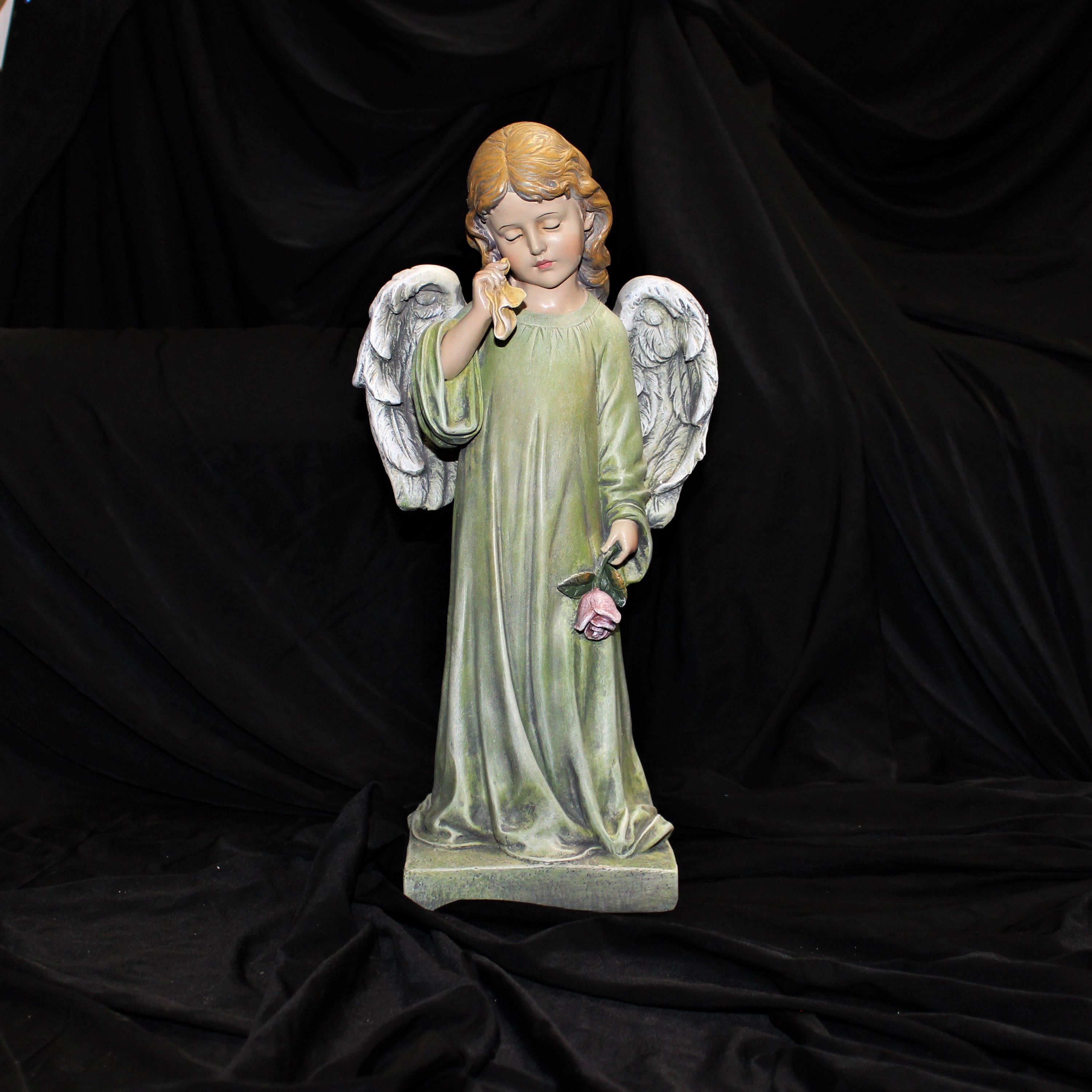 Angel statue holding a pink rose