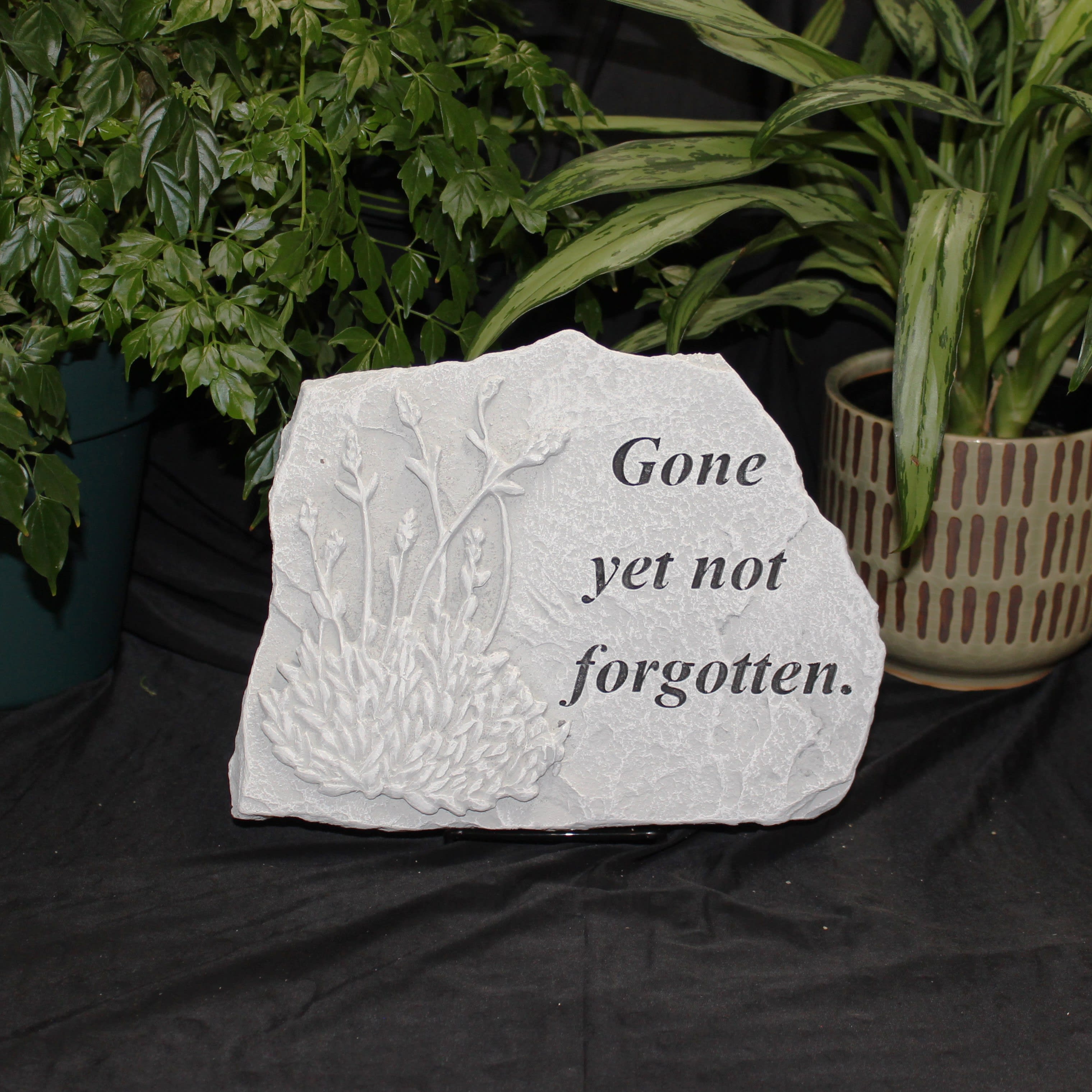 Memorial stone with floral relief and the words "Gone yet not forgotten."