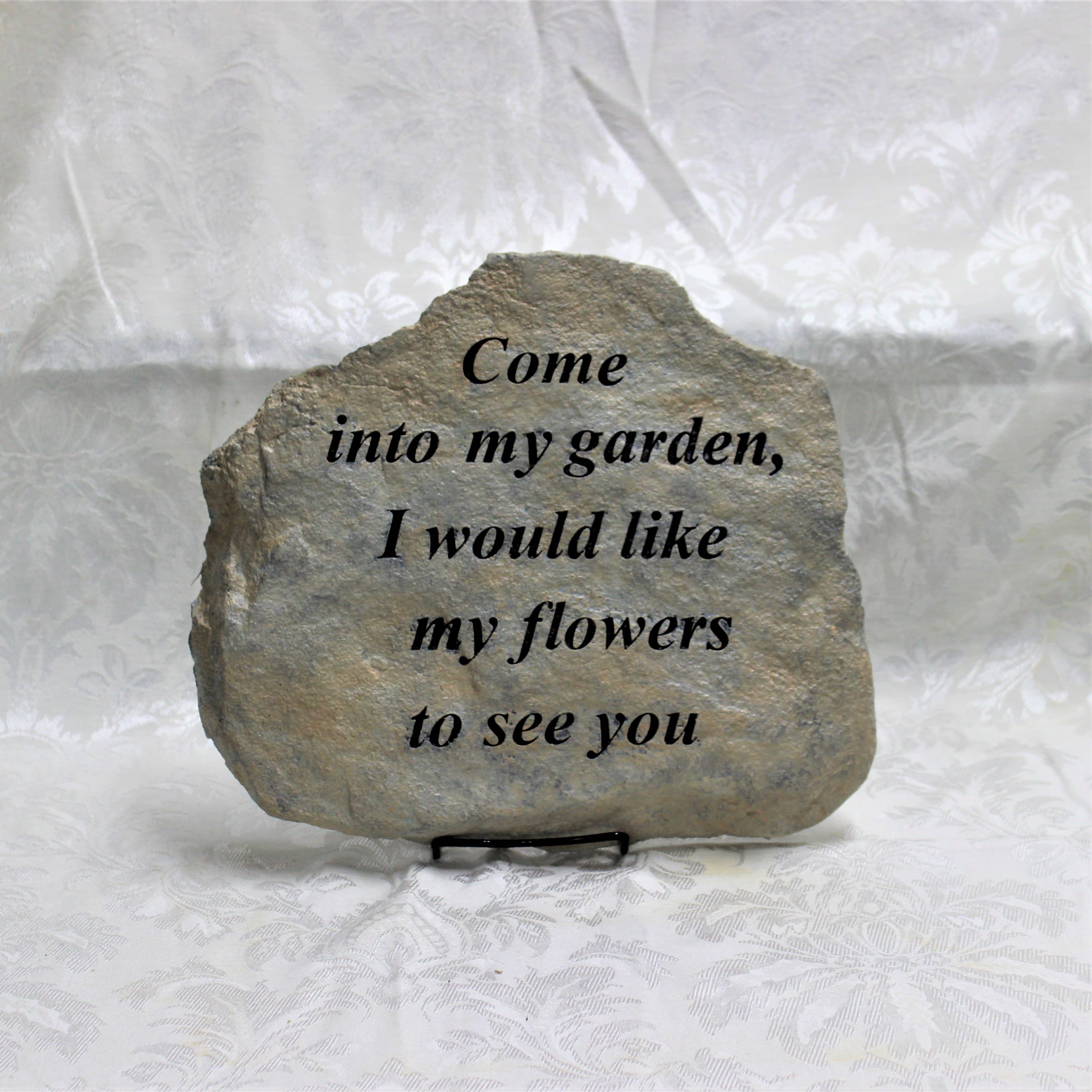 Engraved stone plaque with a garden quote on a stand