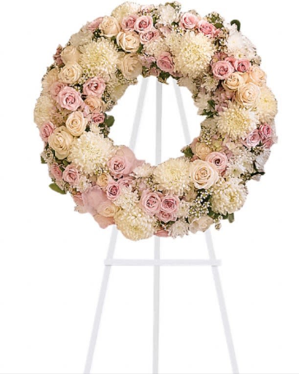 Pastel floral wreath on a white stand