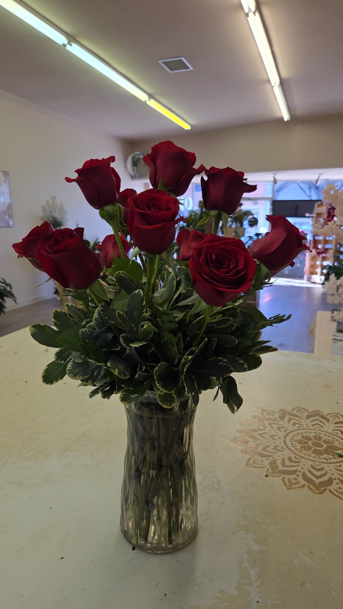 Classic red rose dozen - long stem red roses, seasonal greens, babies breath and other delicate fillers all in a clear glass vase are sure to make anyone's day! Send some elegance their way!