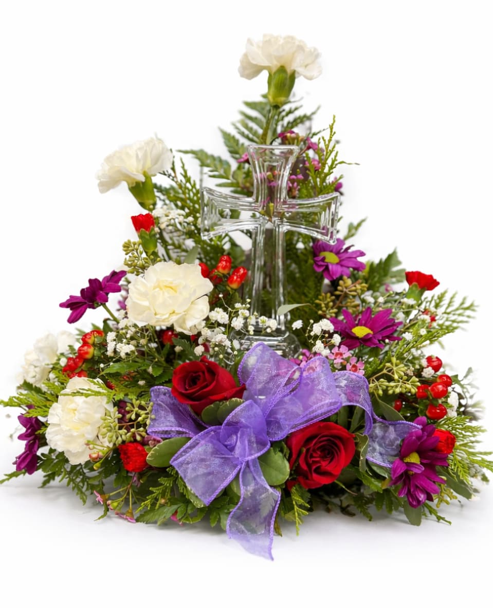Floral arrangement with a clear glass cross and purple ribbon