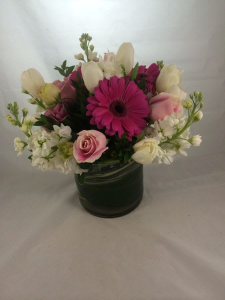 Pink and white mixed flower arrangement in a dark vase