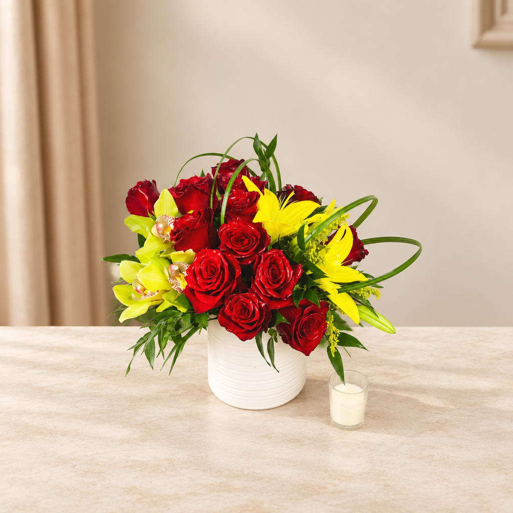 Red roses and yellow lilies arranged in a white vase