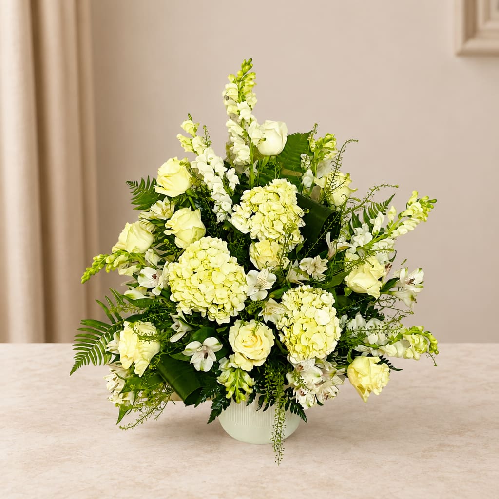 White and pale yellow floral arrangement in a white vase