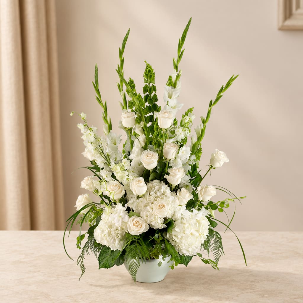 White floral arrangement in a pale vase with tall green spikes