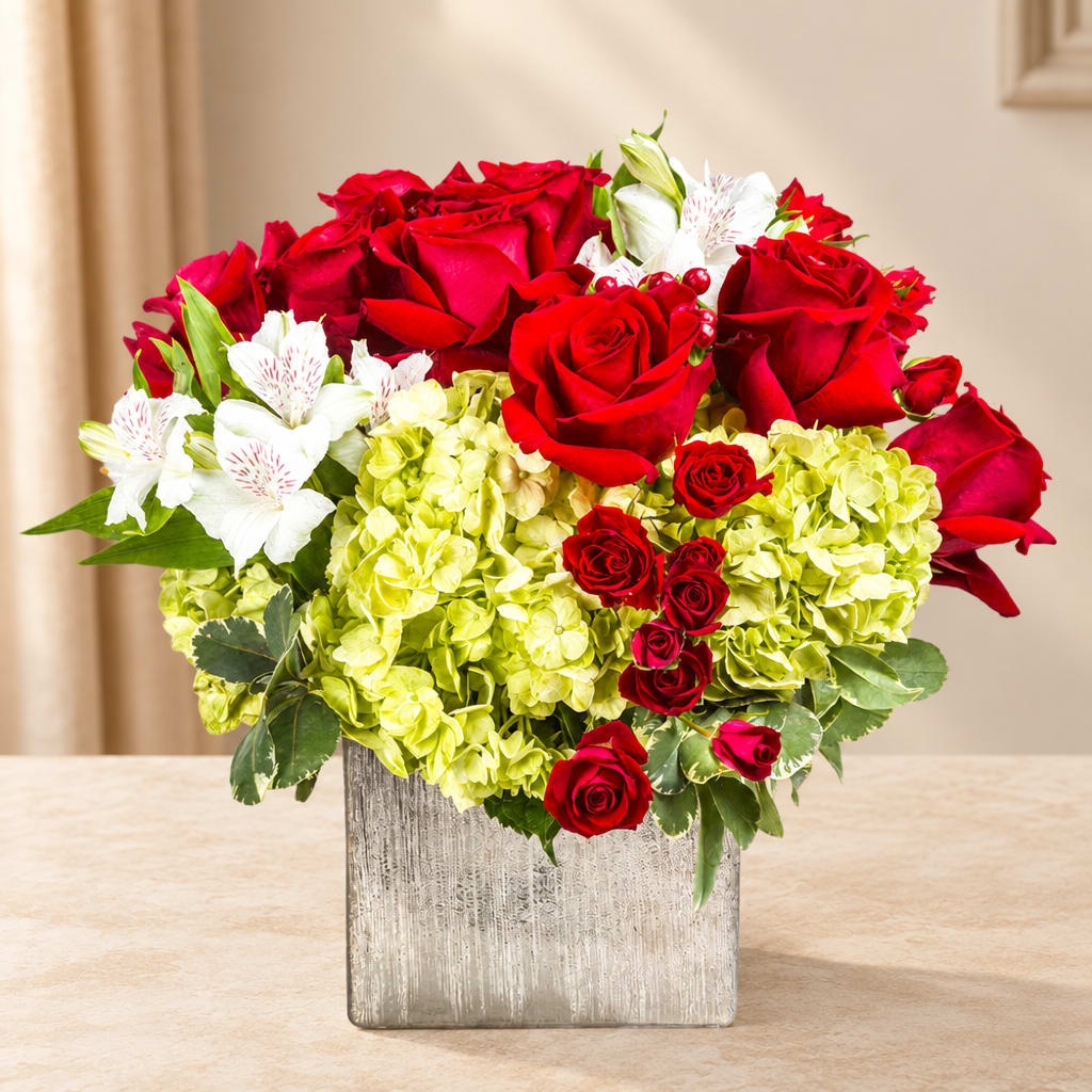 Red roses and white flowers in a square silver vase