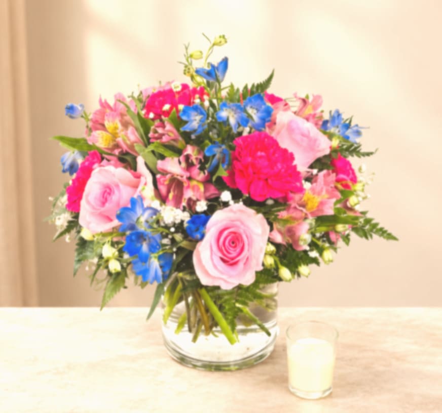 Pink and blue mixed bouquet in a clear glass vase