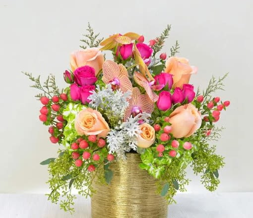Pink and peach roses arranged in a gold vase