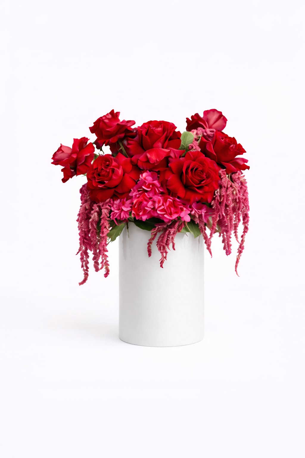 Red rose arrangement in a white cylindrical vase