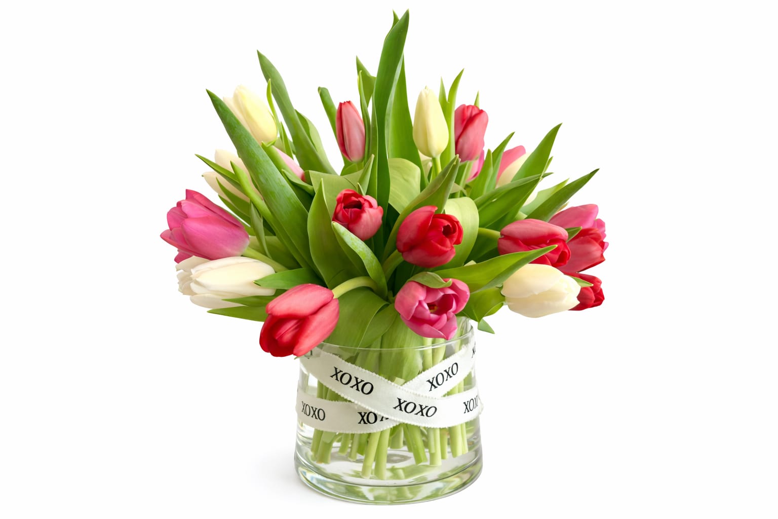 Bouquet of pink, red, and white tulips in a glass vase with XOXO ribbon