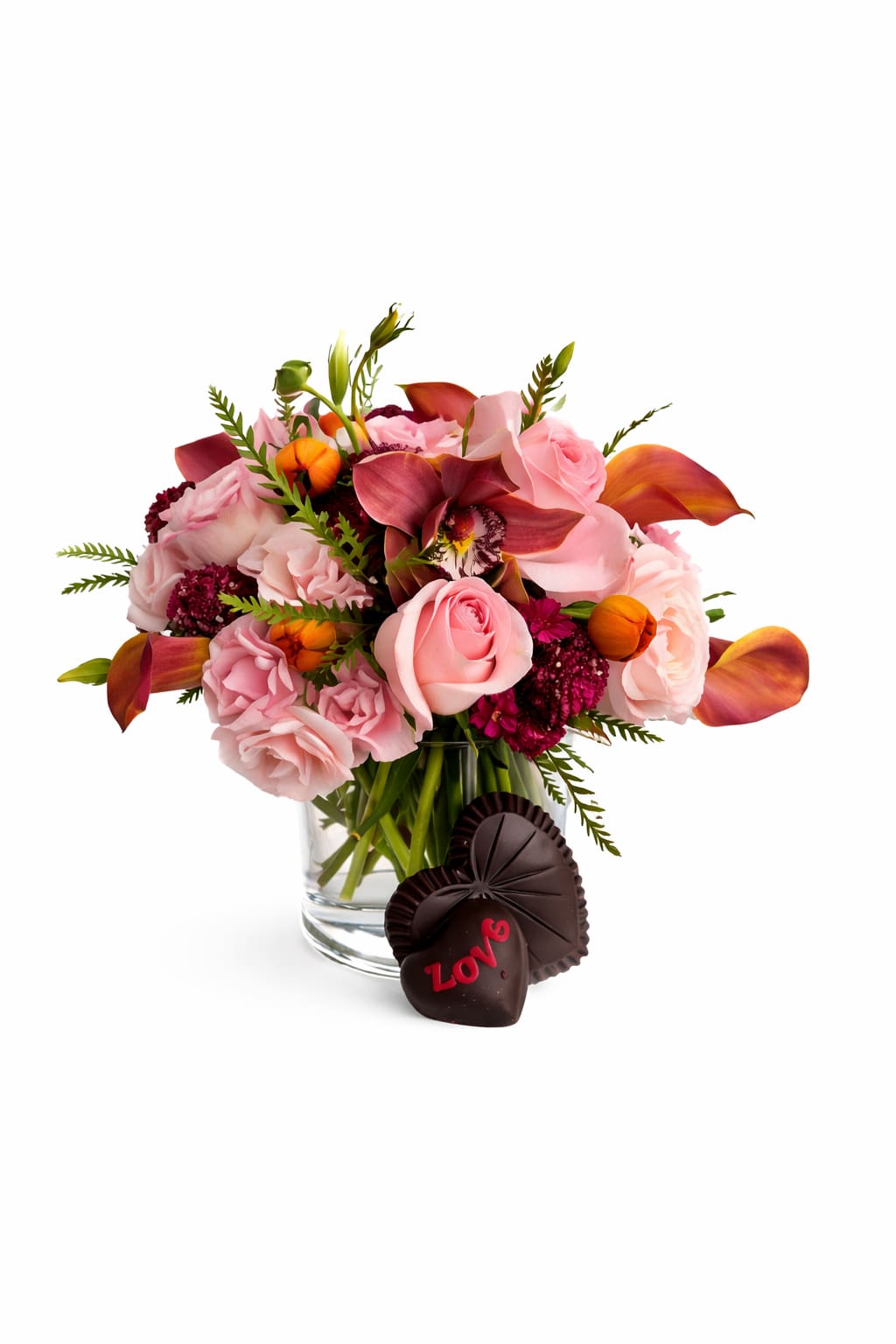 Pink and burgundy floral bouquet in a glass vase with chocolate hearts