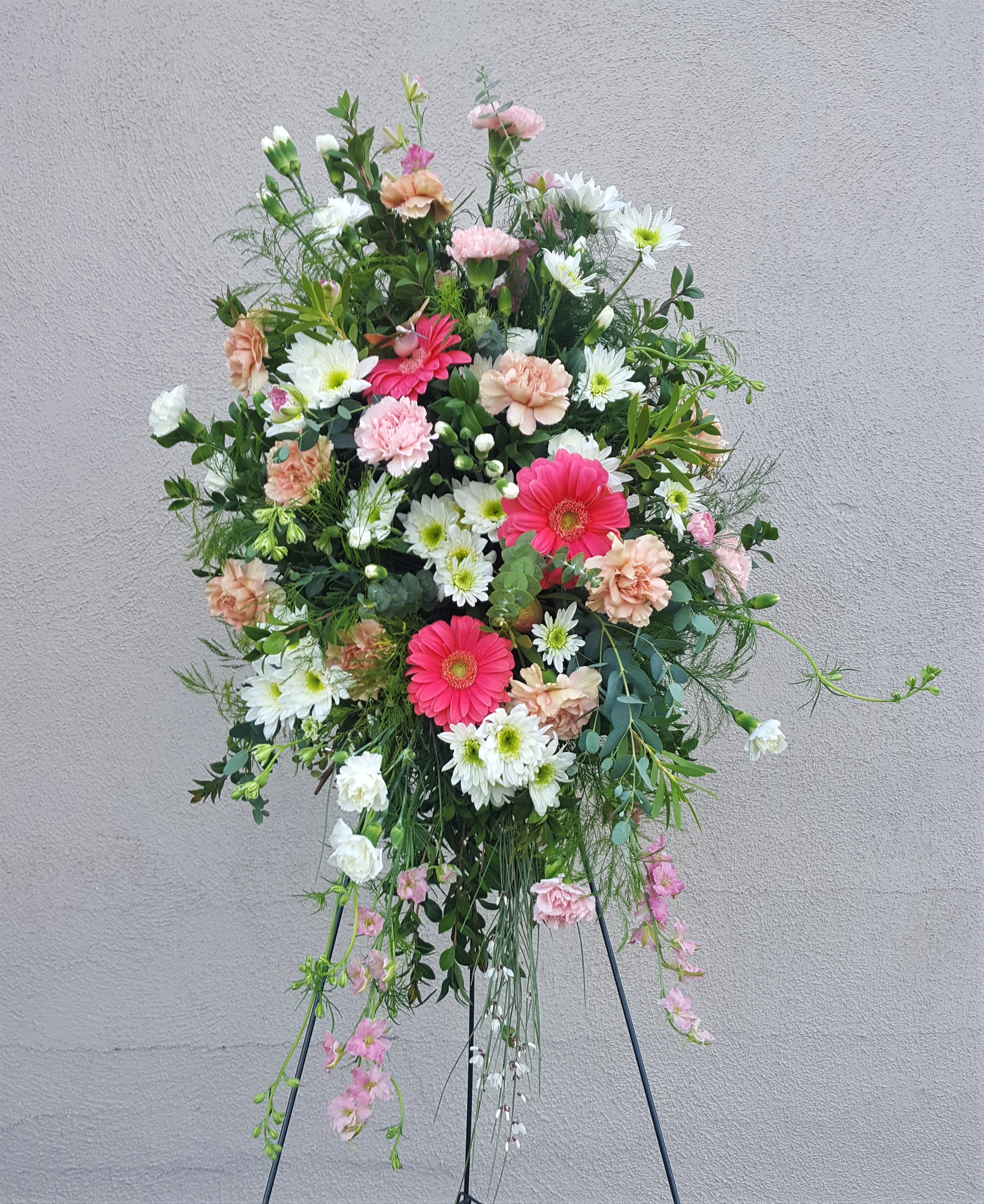 Tall floral standing spray with pink, white, and peach blooms