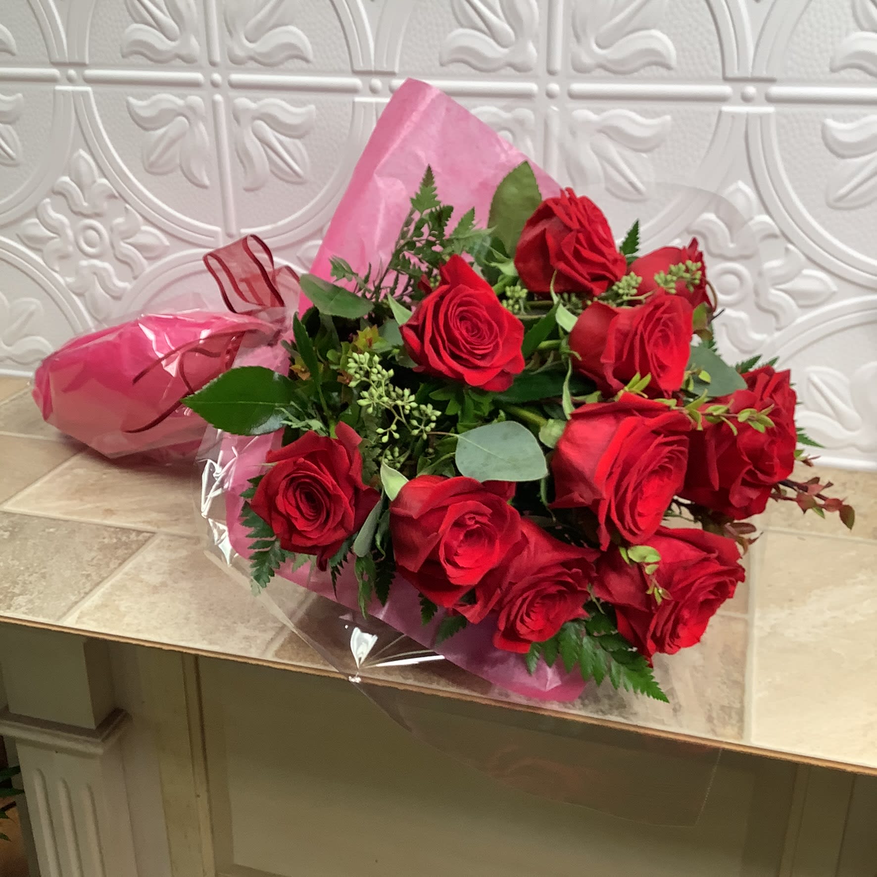 Bouquet of red roses wrapped in pink paper