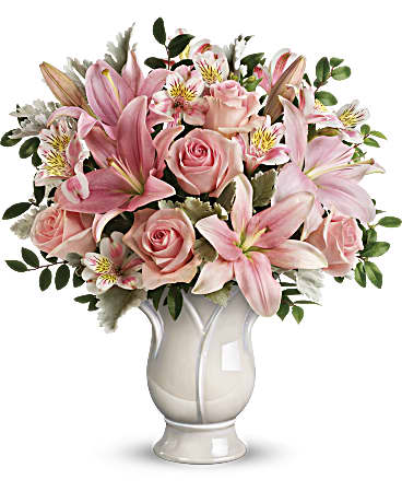 Pink roses and lilies arranged in a white vase