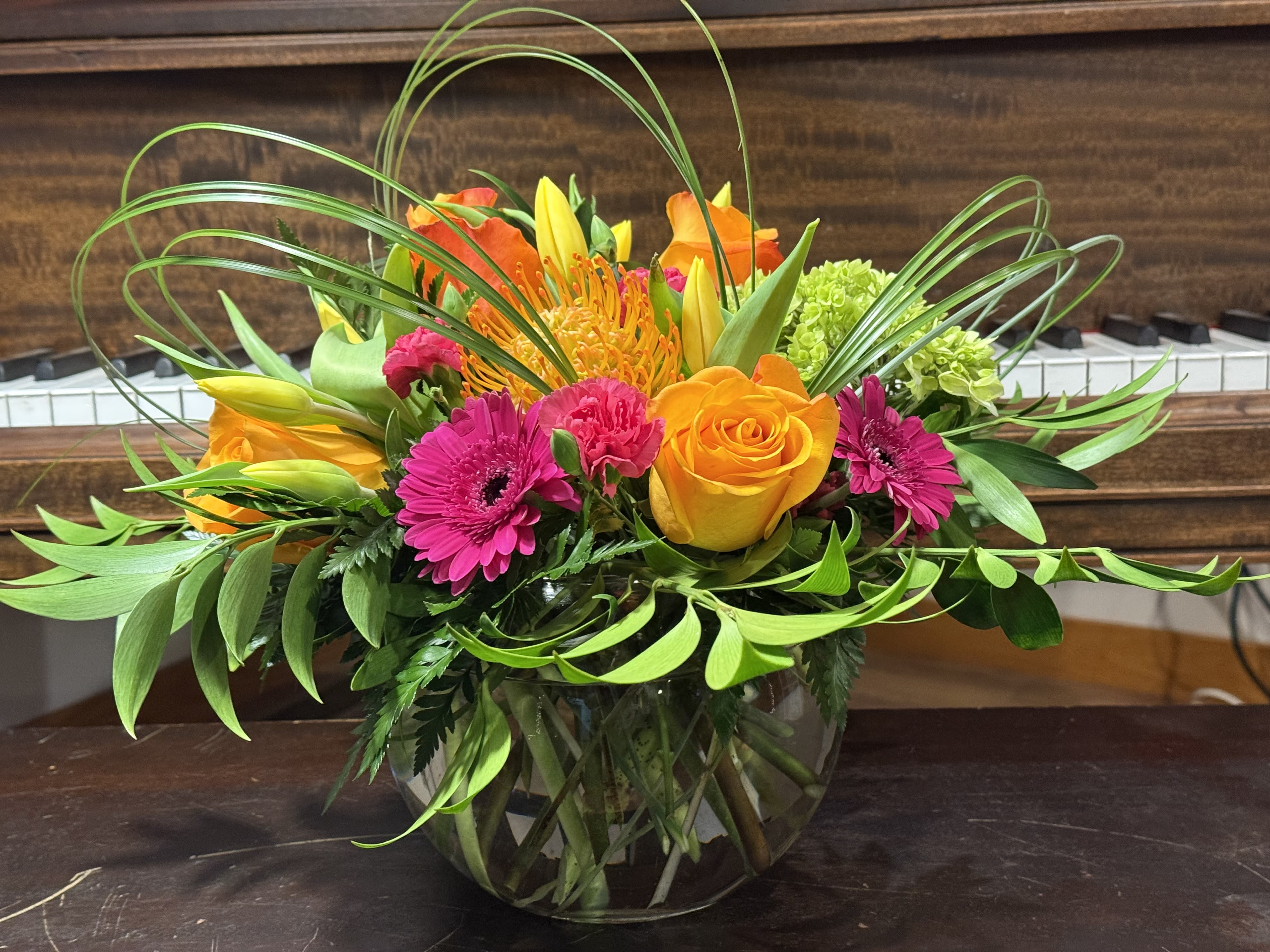Sunset &amp; Smiles - Summer Sunset is one of our most happy arrangements! It includes vibrant orange roses, tulips, tropical protea and gerbera daisies! This will make them smile!!!
