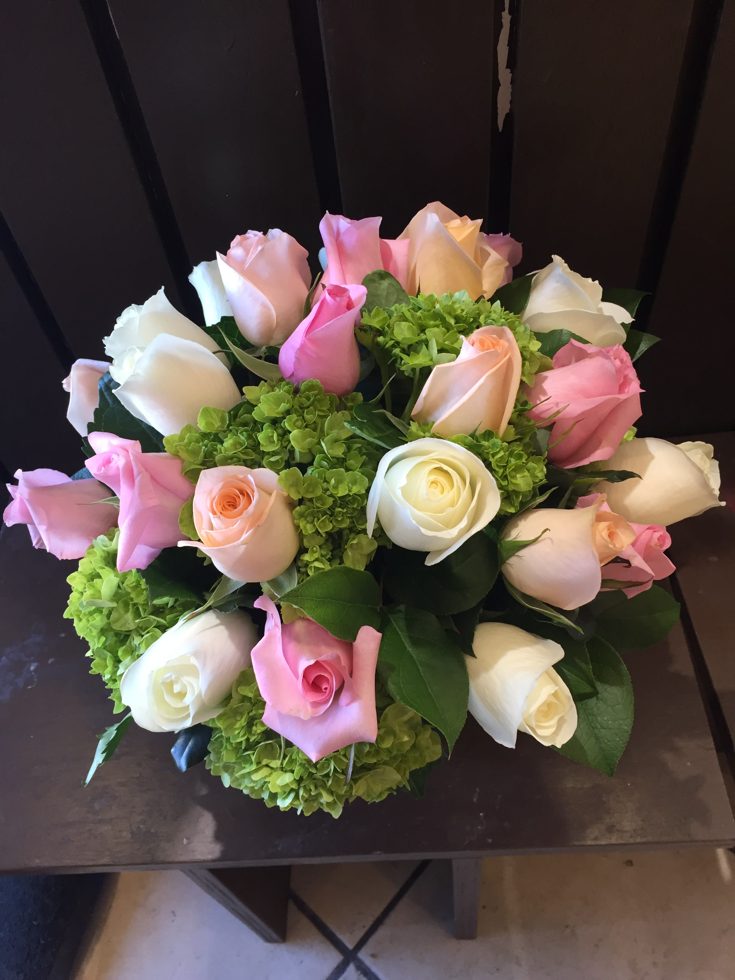 Bouquet of pink, white, and peach roses with green hydrangeas