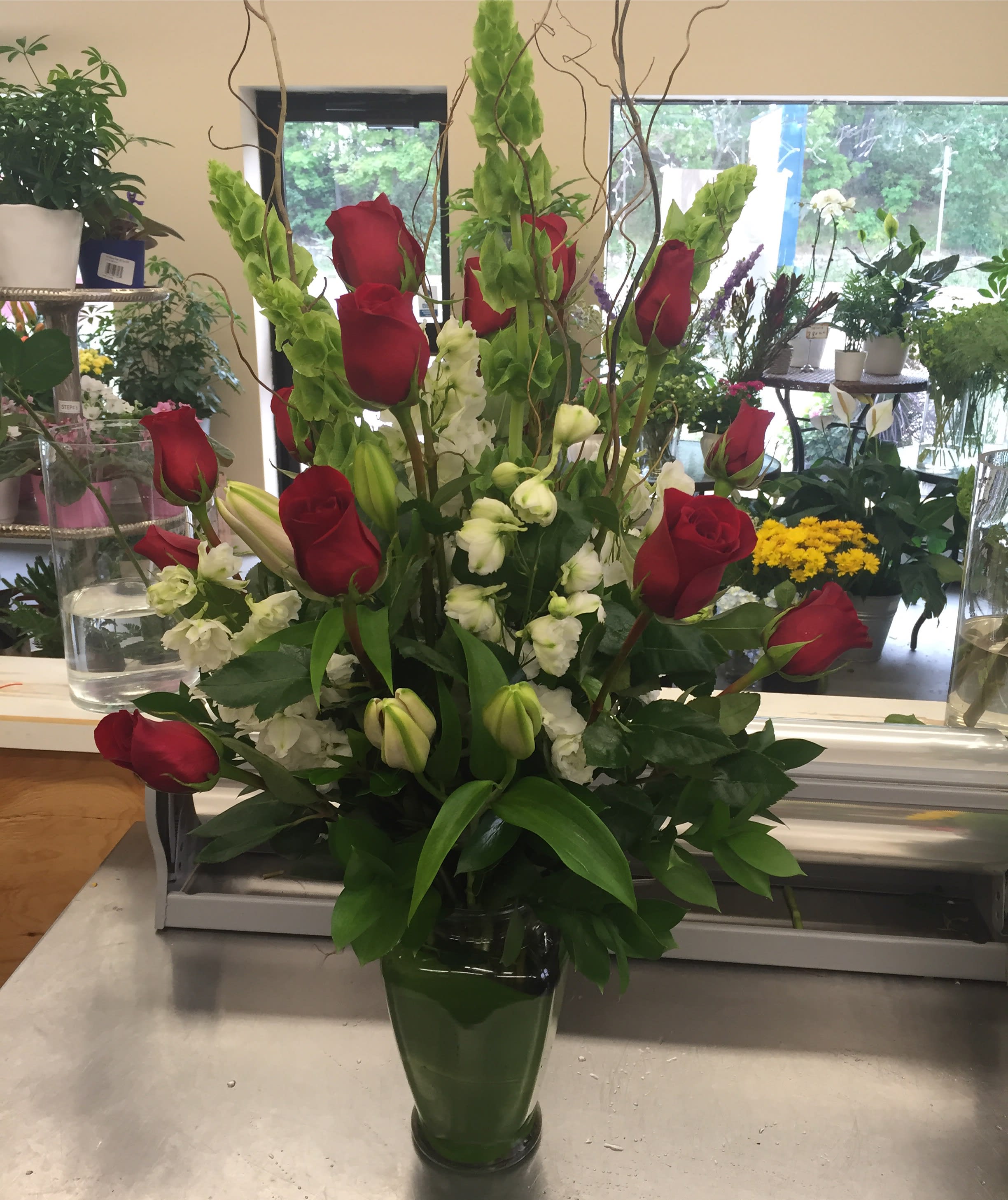 Red roses and white flowers arranged in a glass vase
