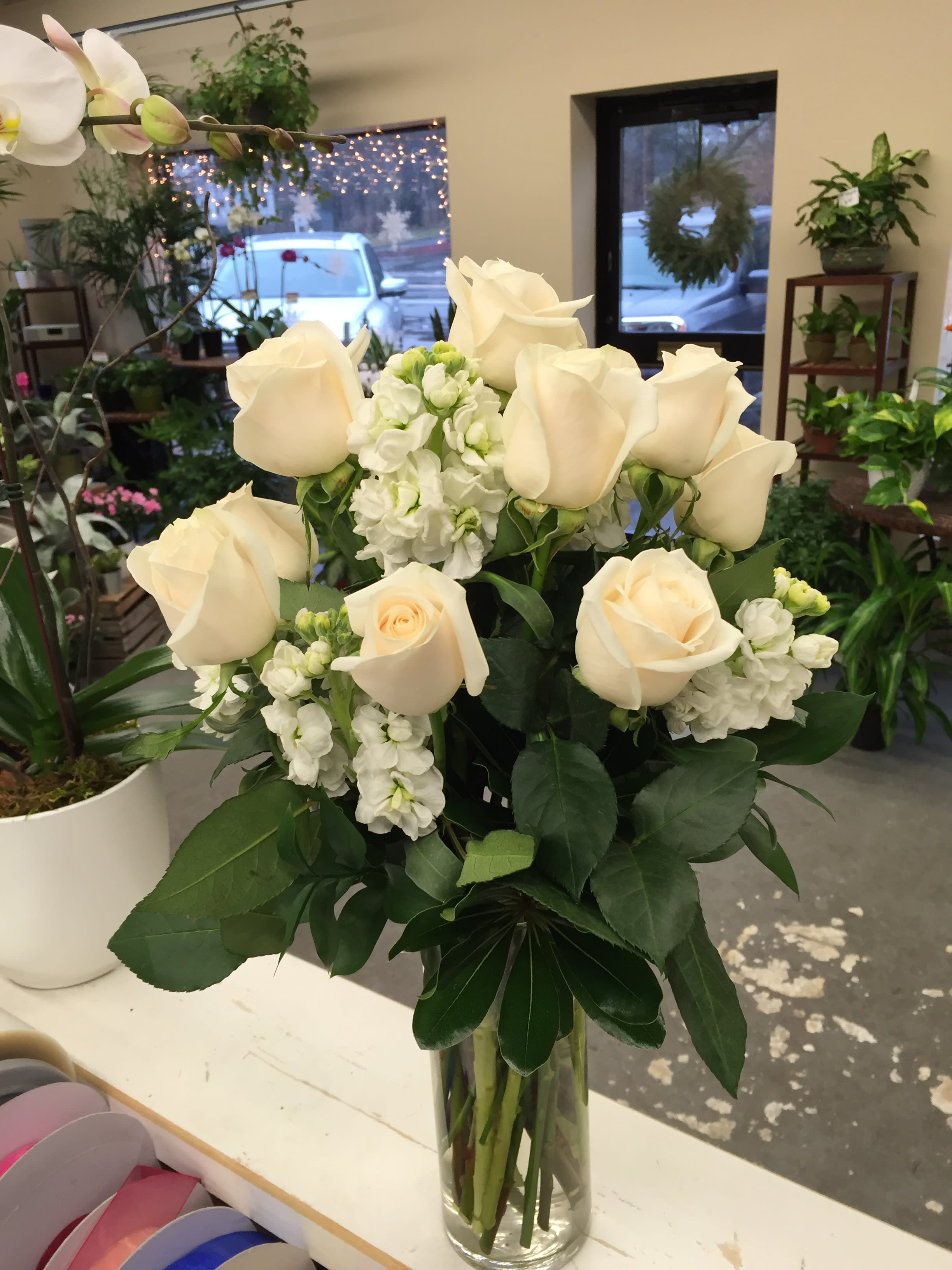White roses and stock in a clear glass vase