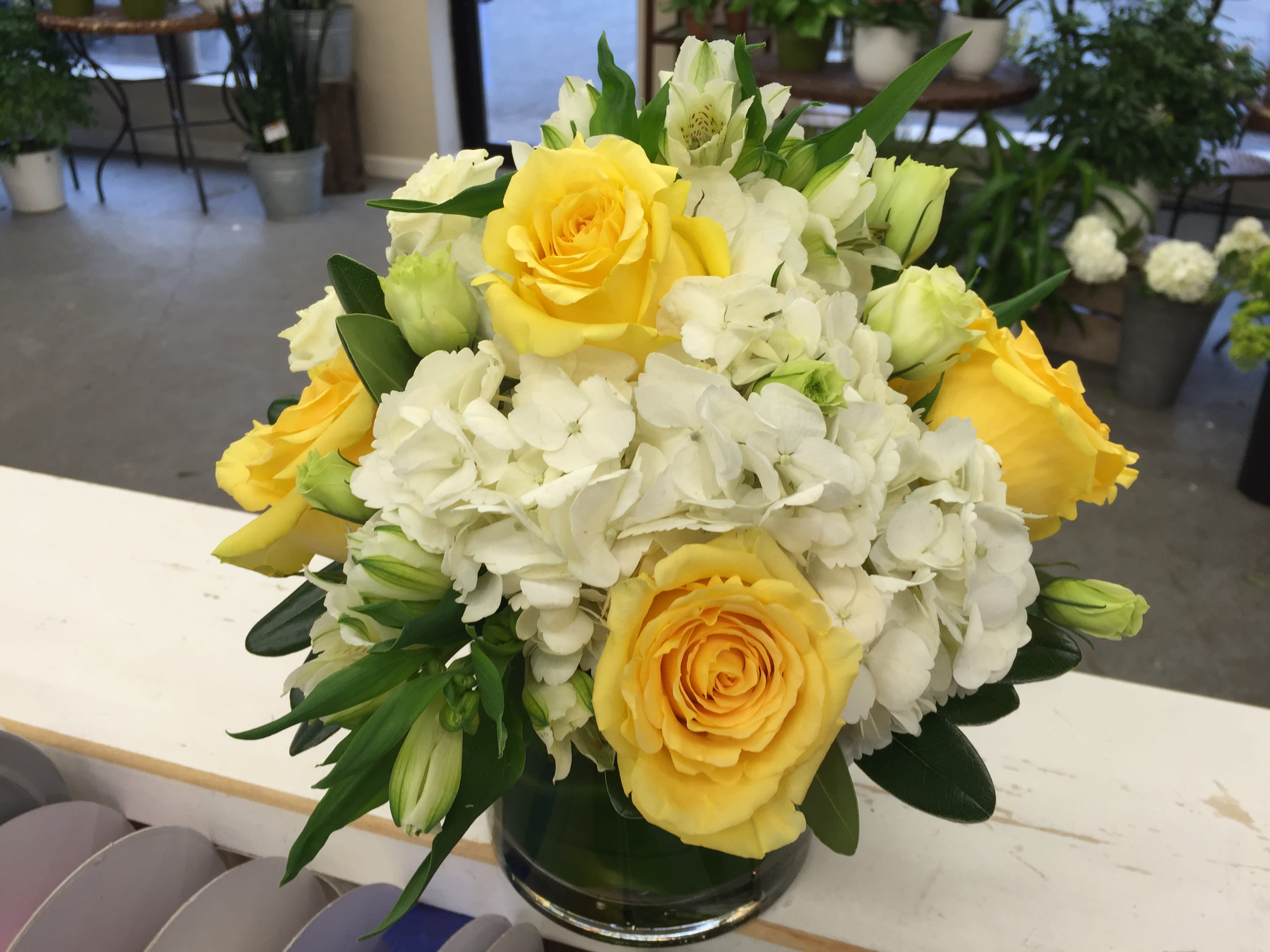 Yellow roses and white hydrangeas in a glass vase