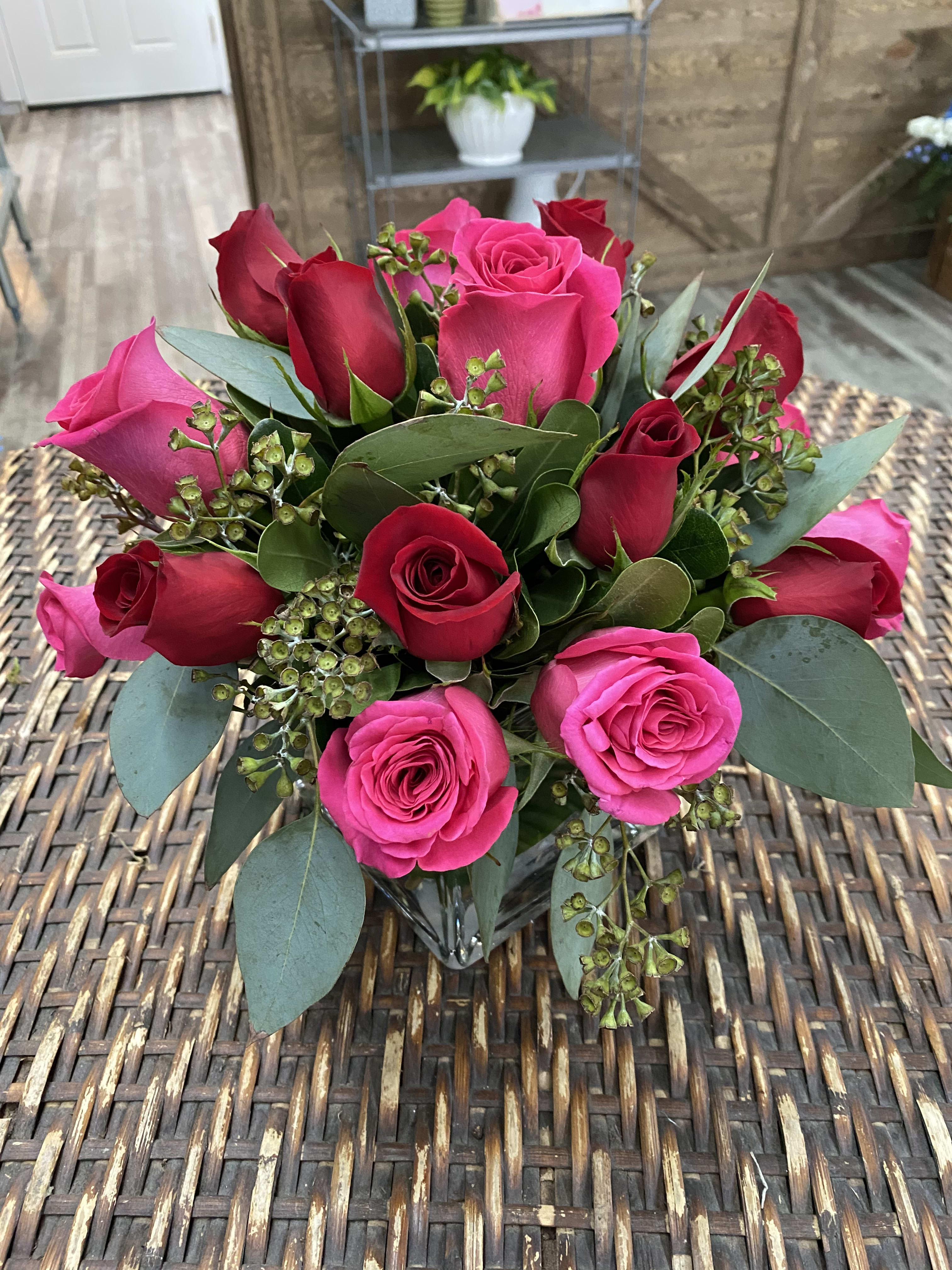 Bouquet of pink and red roses with eucalyptus in a glass vase
