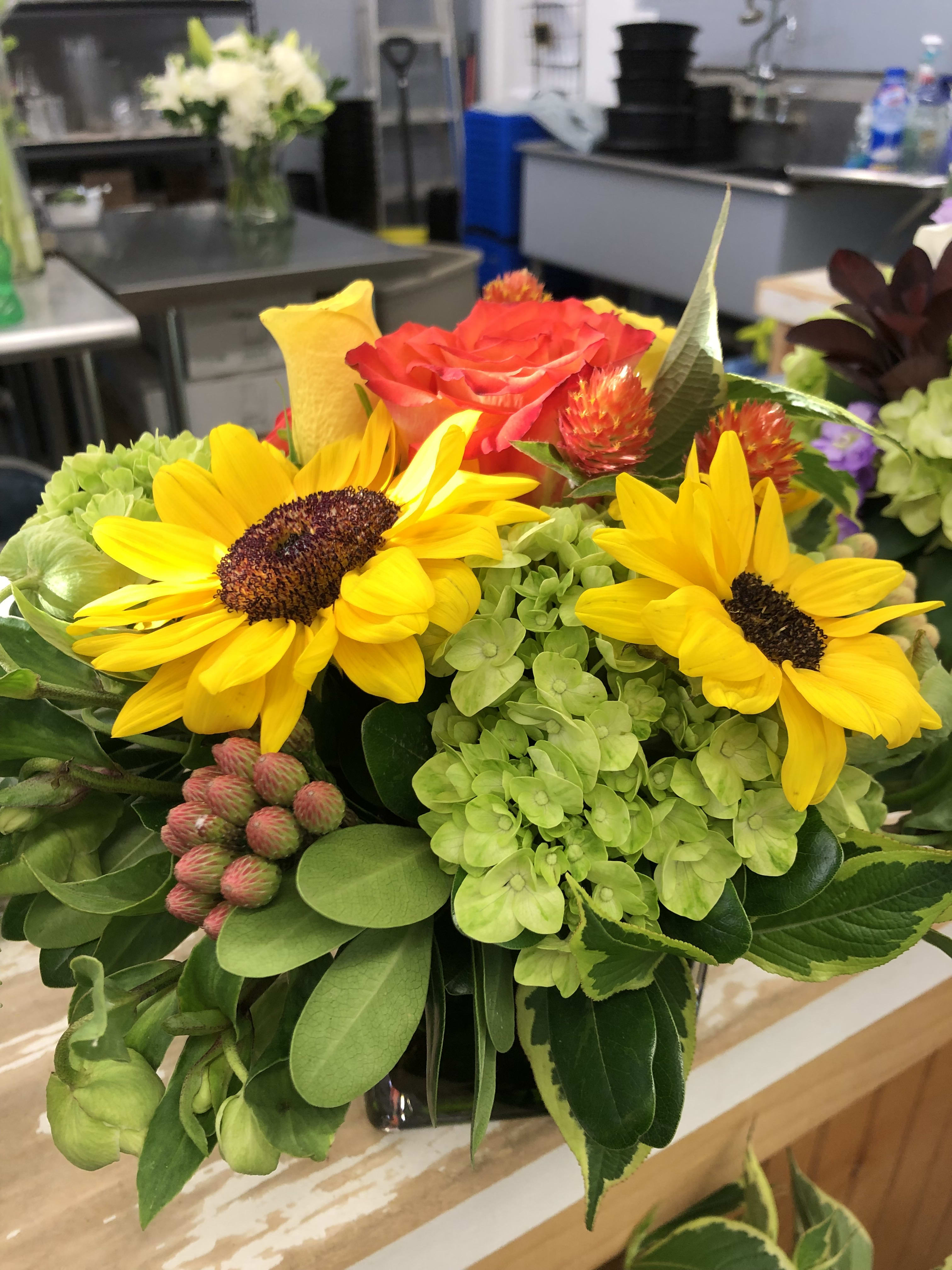 Bouquet with yellow sunflowers, a red rose, and green hydrangea