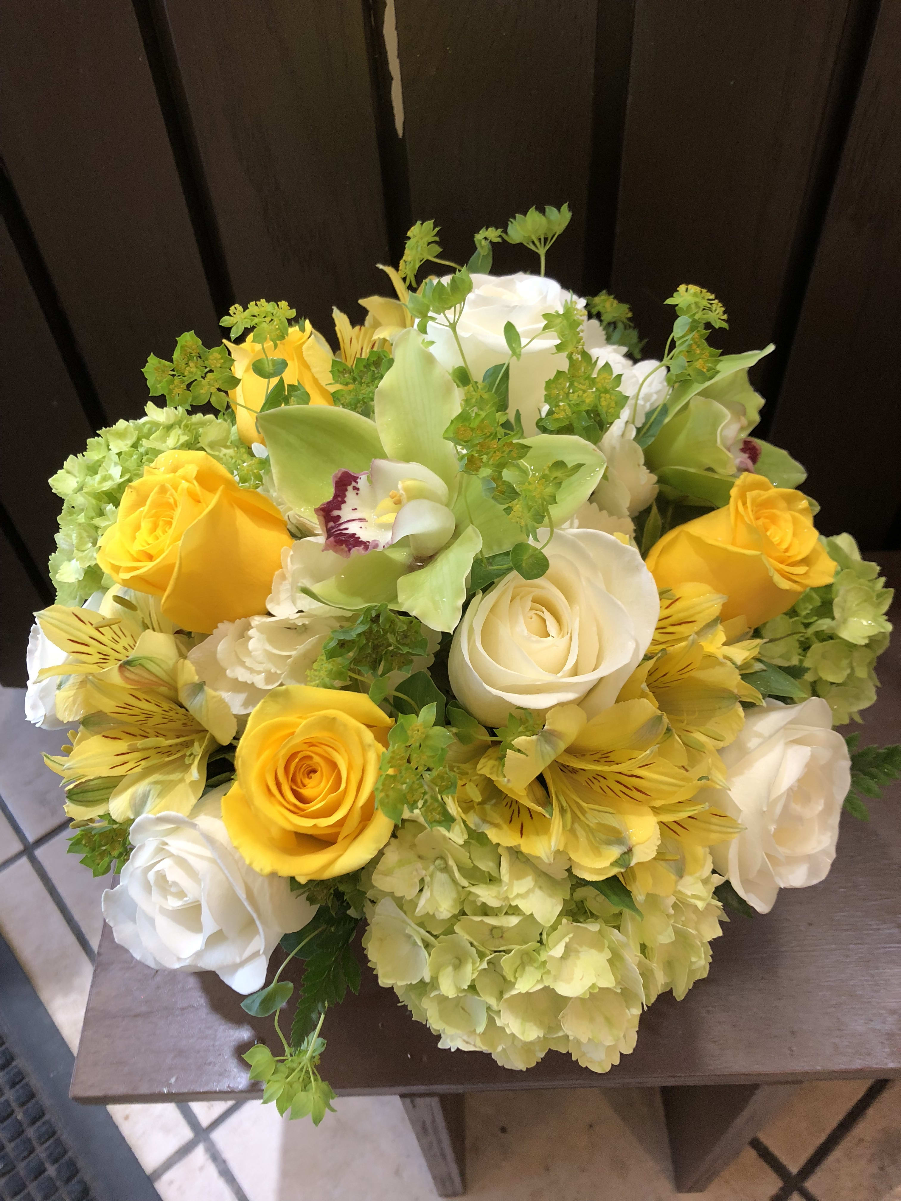 Bouquet of yellow and white roses with green orchids and hydrangeas