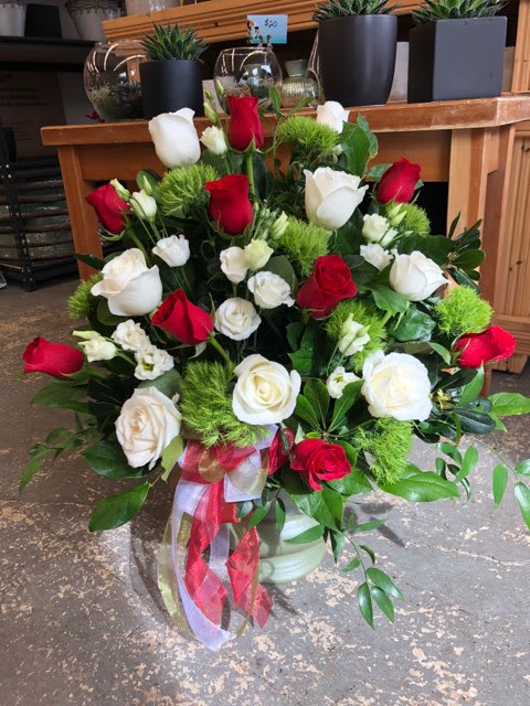 Bouquet of red and white roses with green accents and ribbon