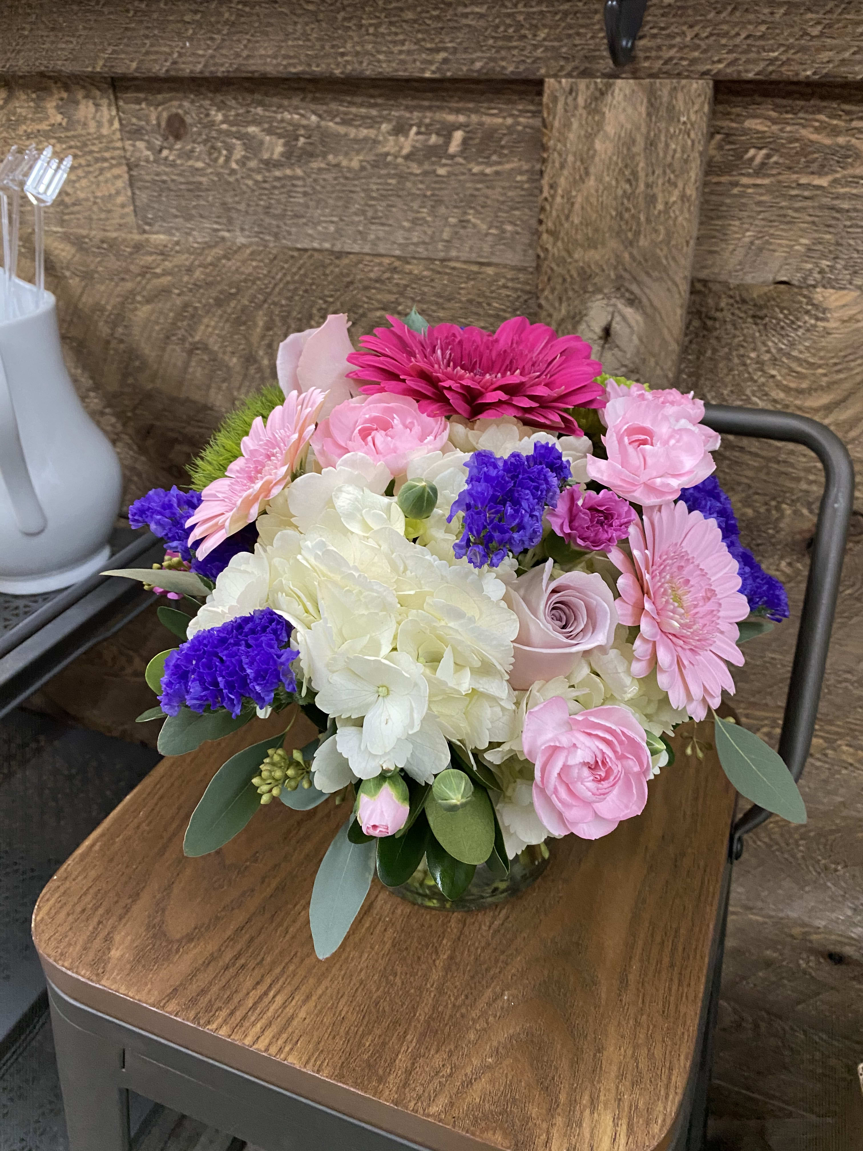 Pink and white mixed flower arrangement in a glass vase