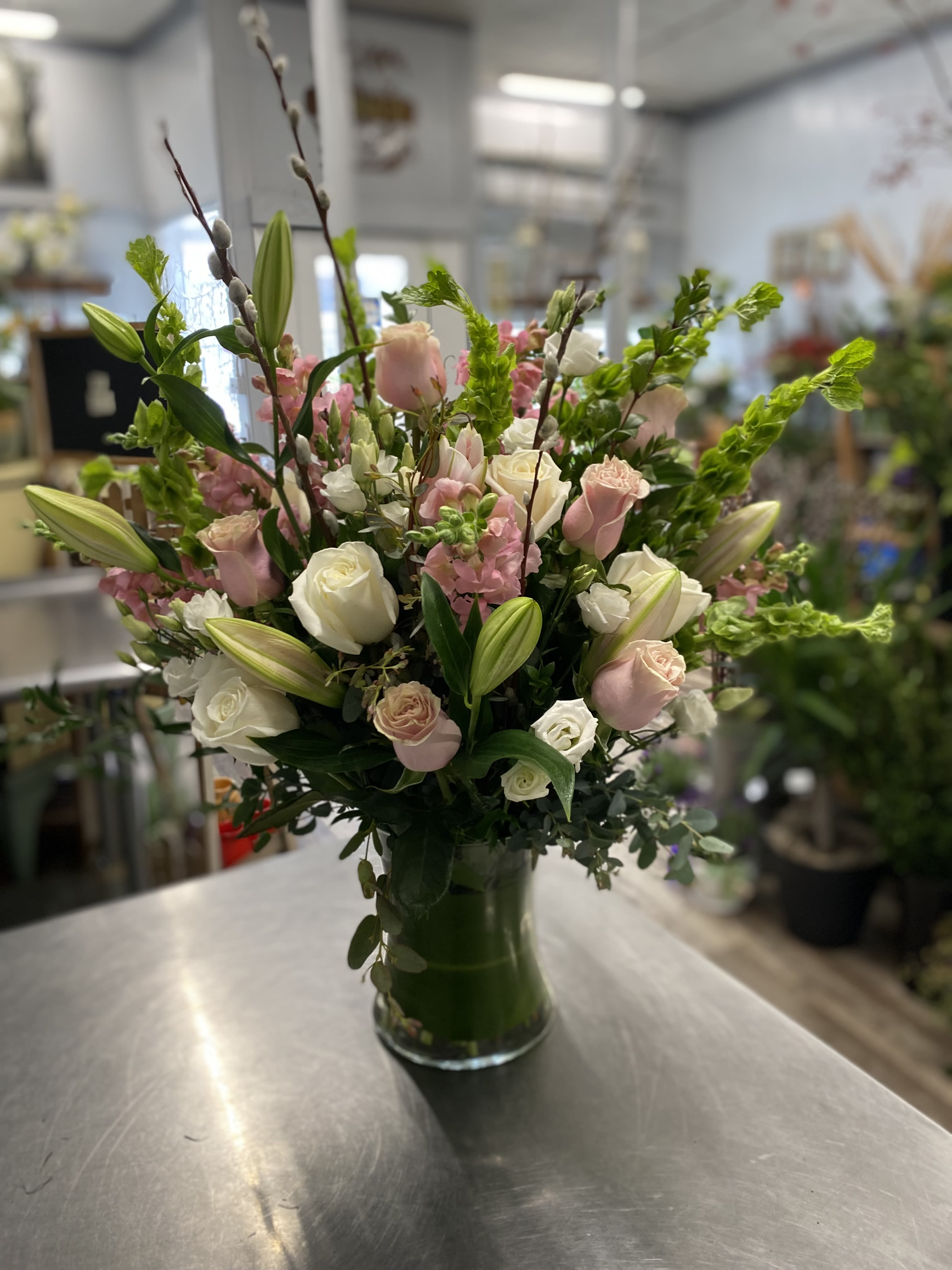 Pink and white rose bouquet with lilies in a glass vase