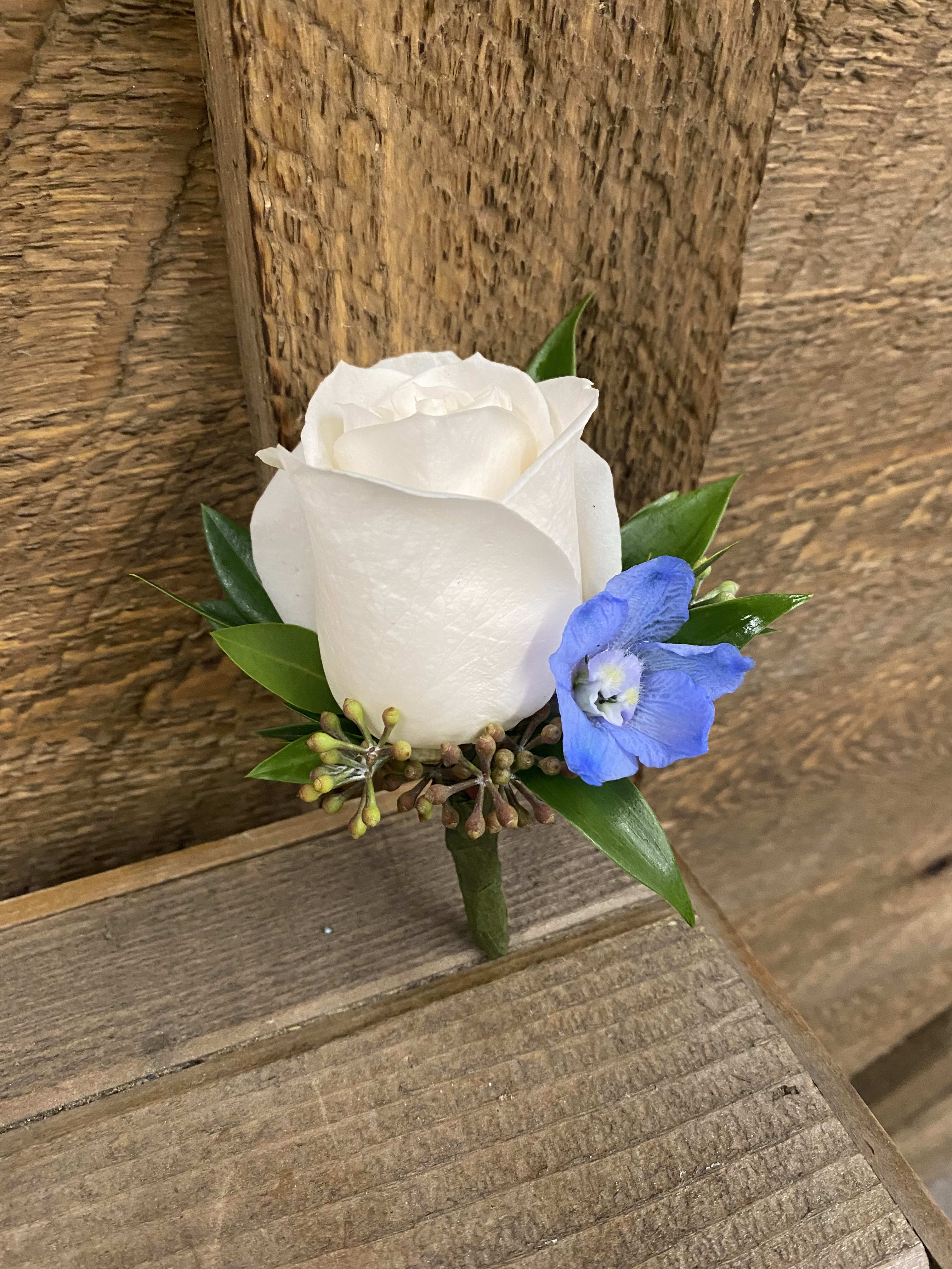 White rose boutonniere with a blue accent flower