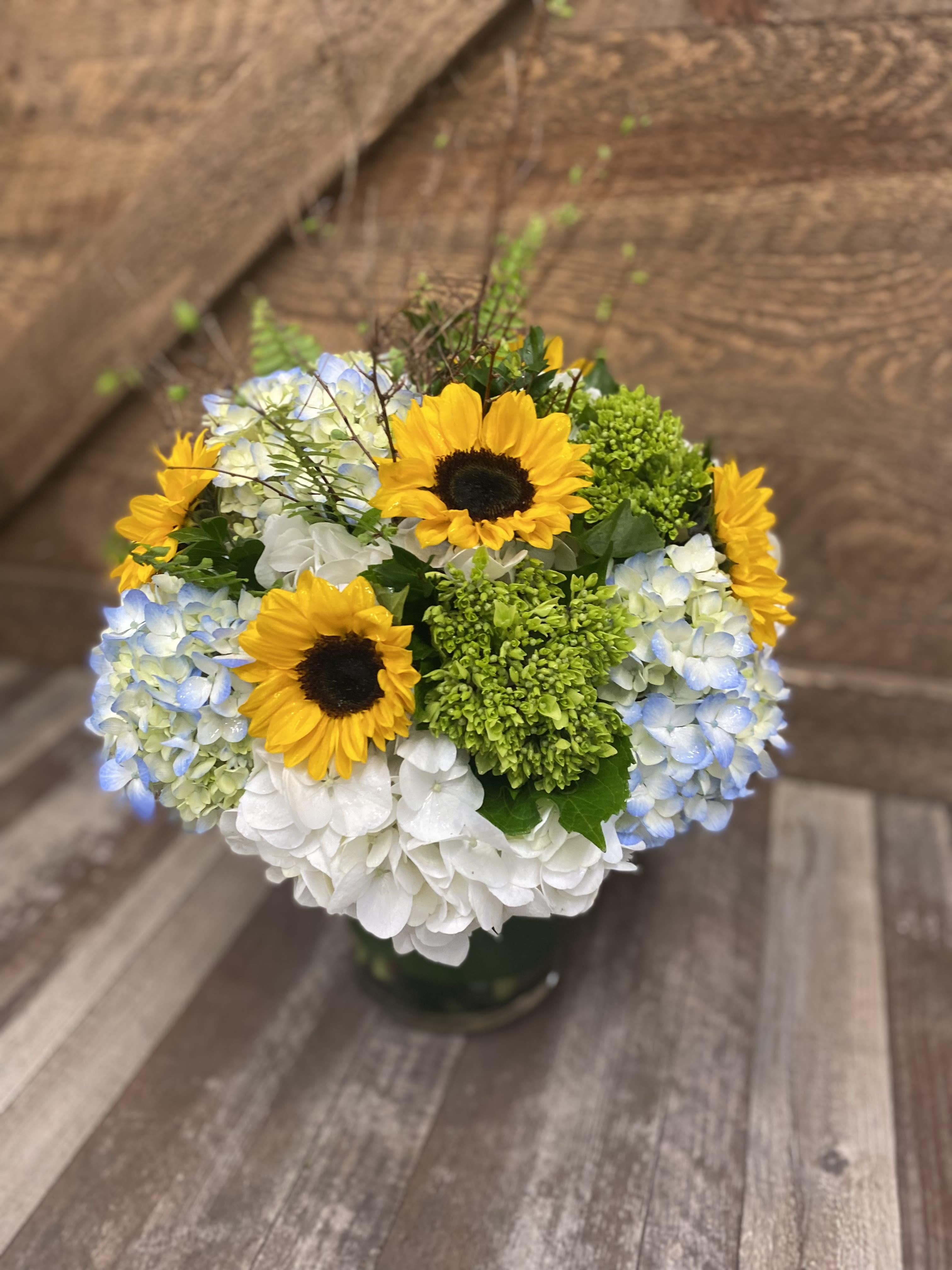Bouquet of sunflowers and blue-white hydrangeas in a vase