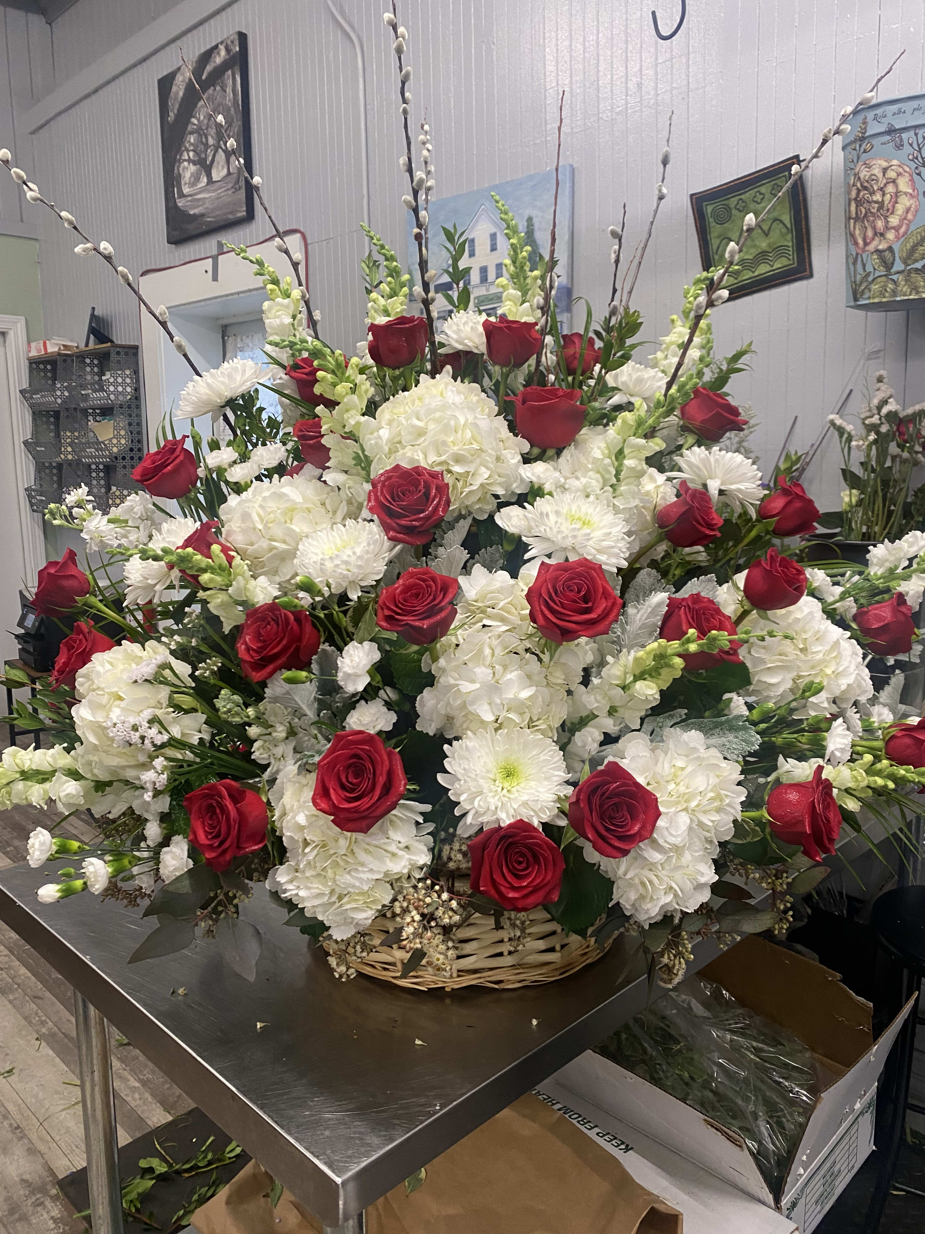 Large basket arrangement of red roses and white flowers