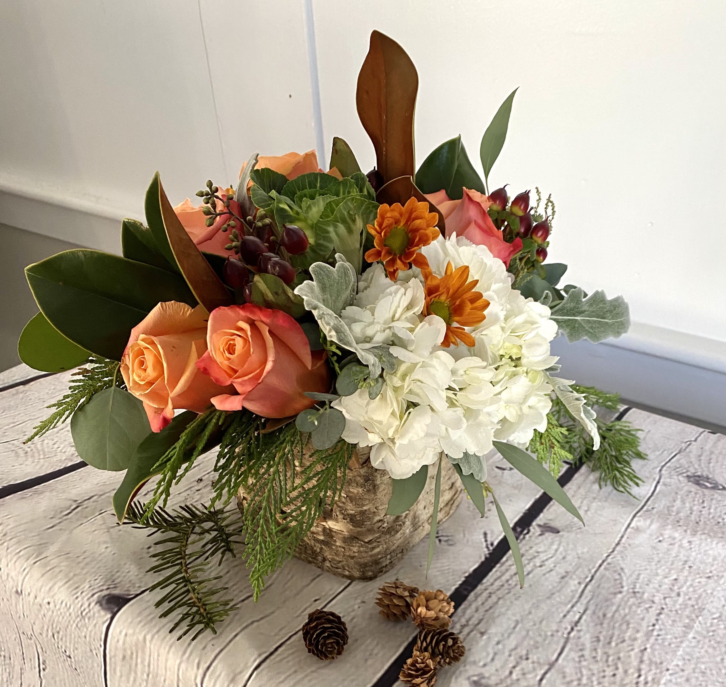 Vanilla Spice - Creamy hydrangeas and warm orange roses combine in our birch wrapped vase for a late fall inspired design. Send cozy wishes of sweet spice to a special someone.  Approx. 10x10