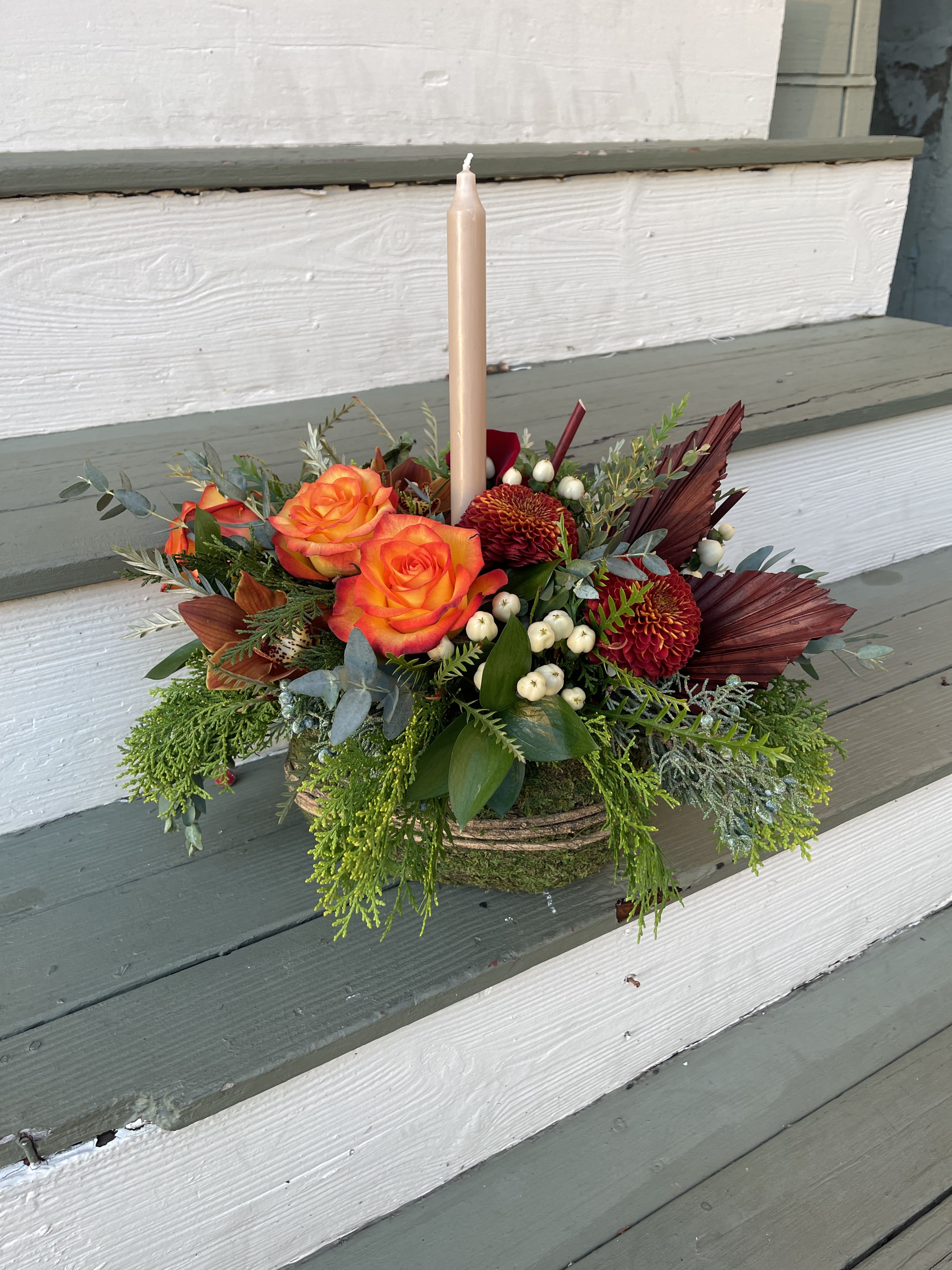 Thankful Garden  - Enjoy the bounty of the season with this lush arranged floral design in a verdant moss basket. This round and low centerpiece is a gorgeous and gardeny collection of autumnal hues.  Approx. 12x14  Includes a taper candle which can easily be removed if you wish. 