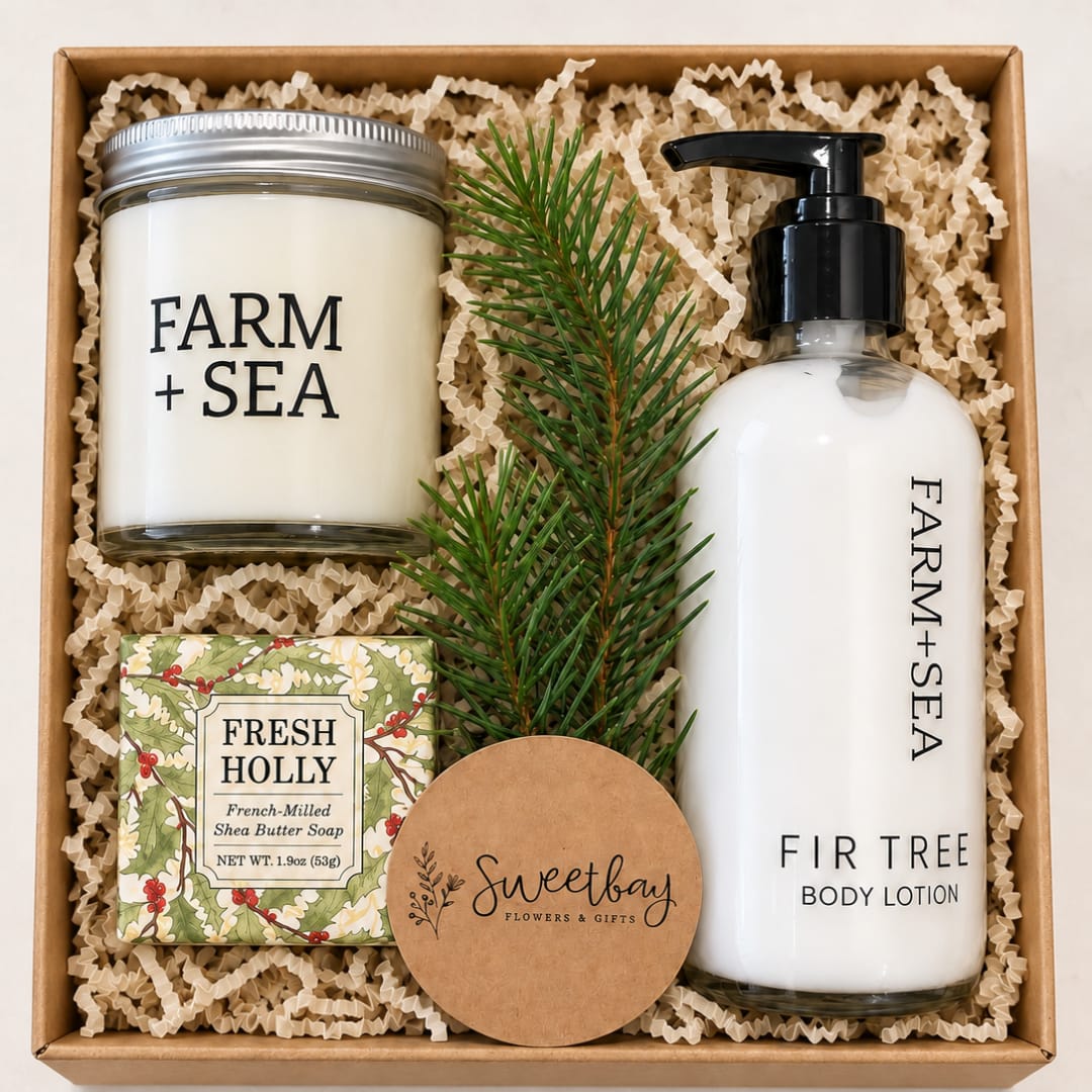 Holiday gift box with a candle, lotion, soap, and pine sprig