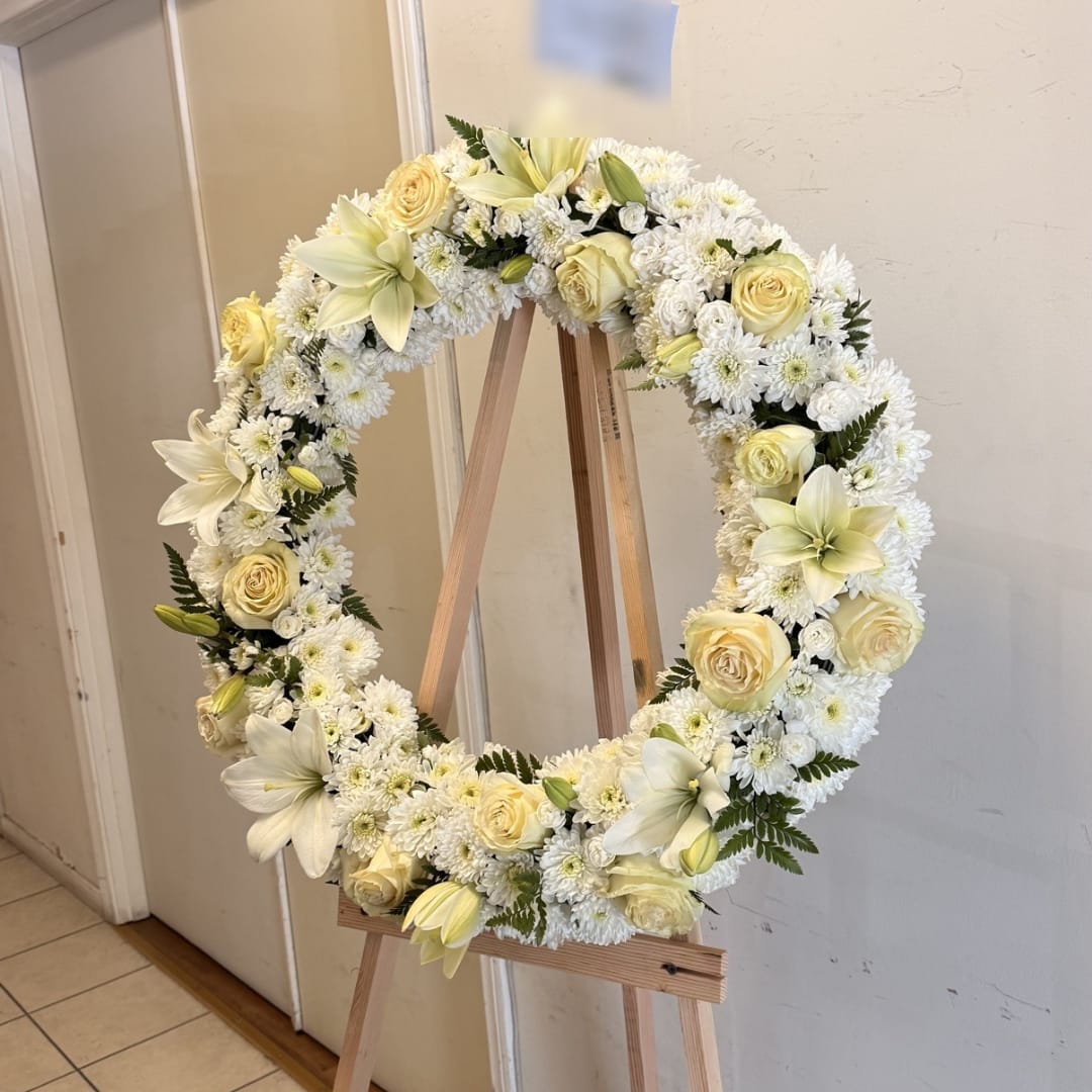 Cream and white floral wreath on a wooden easel