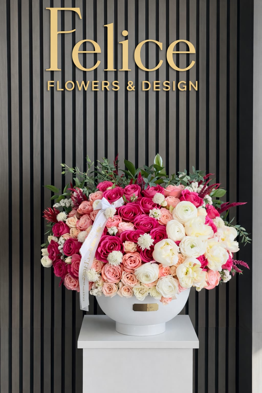 Large pink and white rose arrangement in a white vase