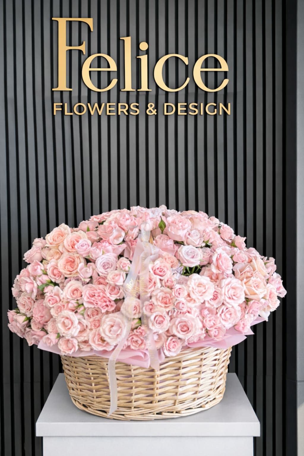 Large basket of pale pink roses with a ribbon bow