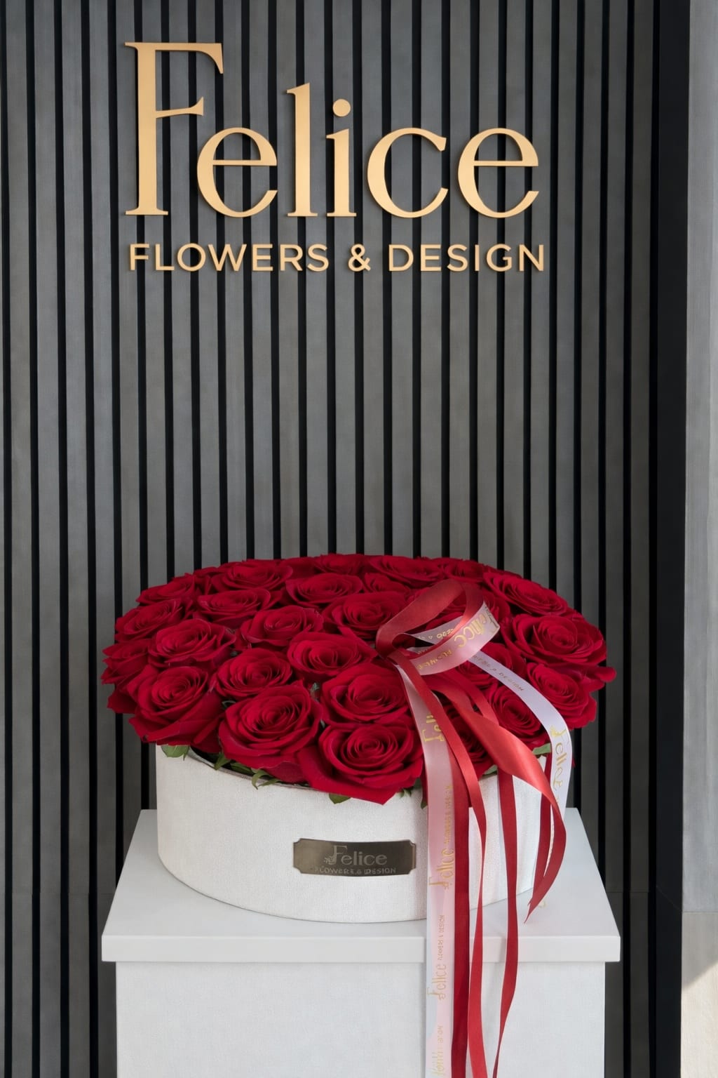 Round box of red roses with a ribbon bow